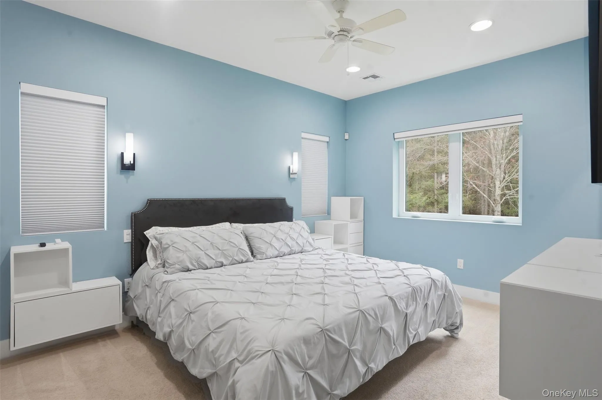 Carpeted bedroom featuring recessed lighting, a ceiling fan, and multiple windows Carpeted bedroom featuring recessed lighting, a ceiling fan, and multiple windows