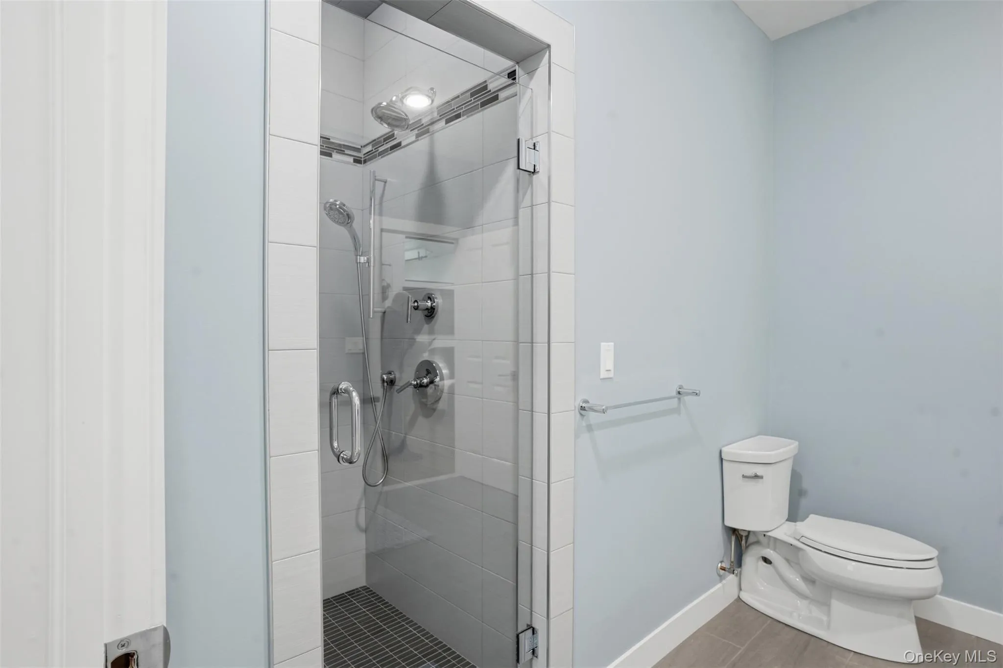 Modern walk-in shower with clear glass enclosure and tiled walls Modern walk-in shower with clear glass enclosure and tiled walls