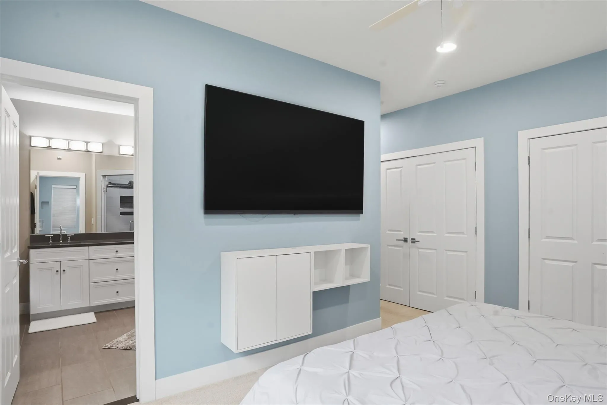 Bedroom featuring light blue walls, white trim, and a ceiling fan Bedroom featuring light blue walls, white trim, and a ceiling fan