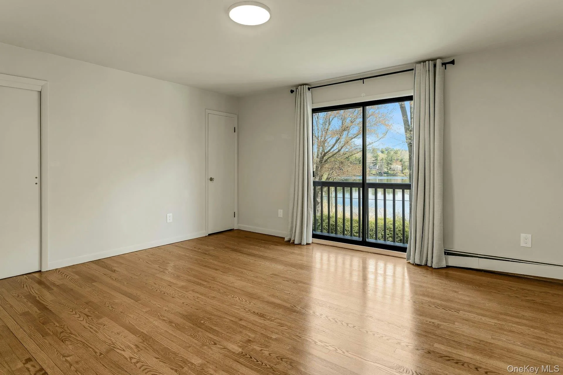 Large Door to Balcony Overlooking View of Lake & Shows Closets Large Door to Balcony Overlooking View of Lake & Shows Closets