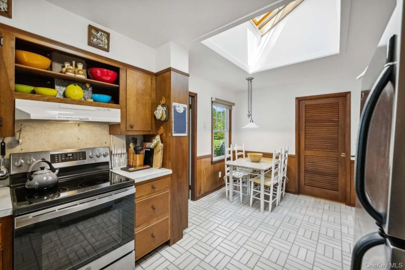 Kitchen featuring new stove, skylight, and stainless steel appliances Kitchen featuring new stove, skylight, and stainless steel appliances