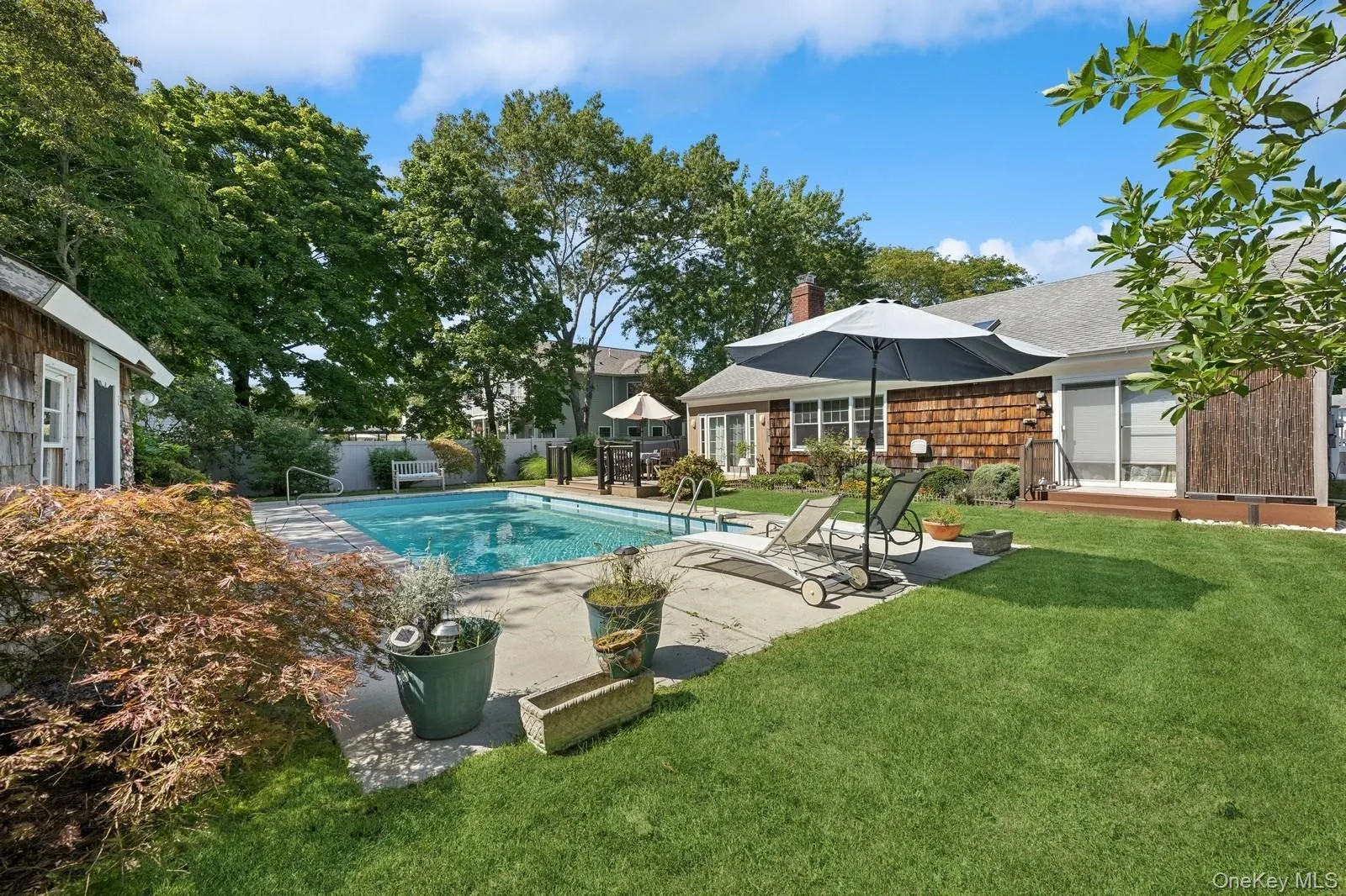 View of pool with a lounge chair patio and expansive lawn View of pool with a lounge chair patio and expansive lawn