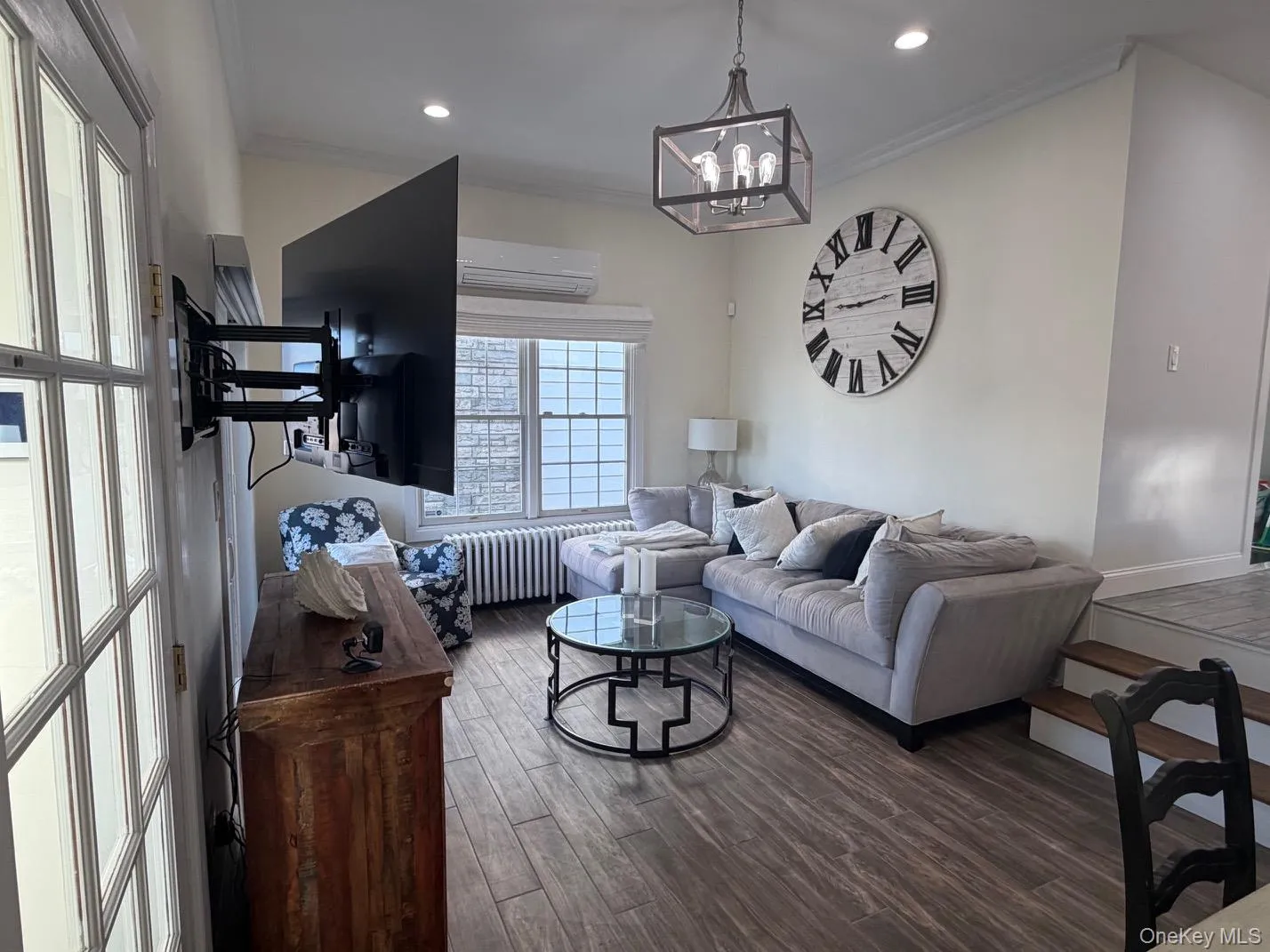 Spacious living area featuring ceramic tile flooring, recessed lighting, and a contemporary chandelier Spacious living area featuring ceramic tile flooring, recessed lighting, and a contemporary chandelier