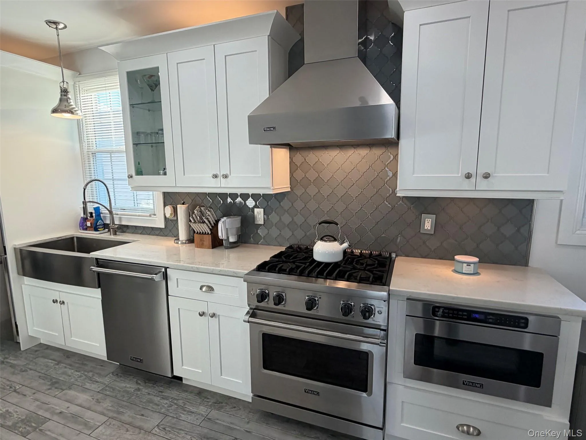 Kitchen featuring white shaker-style cabinetry and stainless steel appliances Kitchen featuring white shaker-style cabinetry and stainless steel appliances