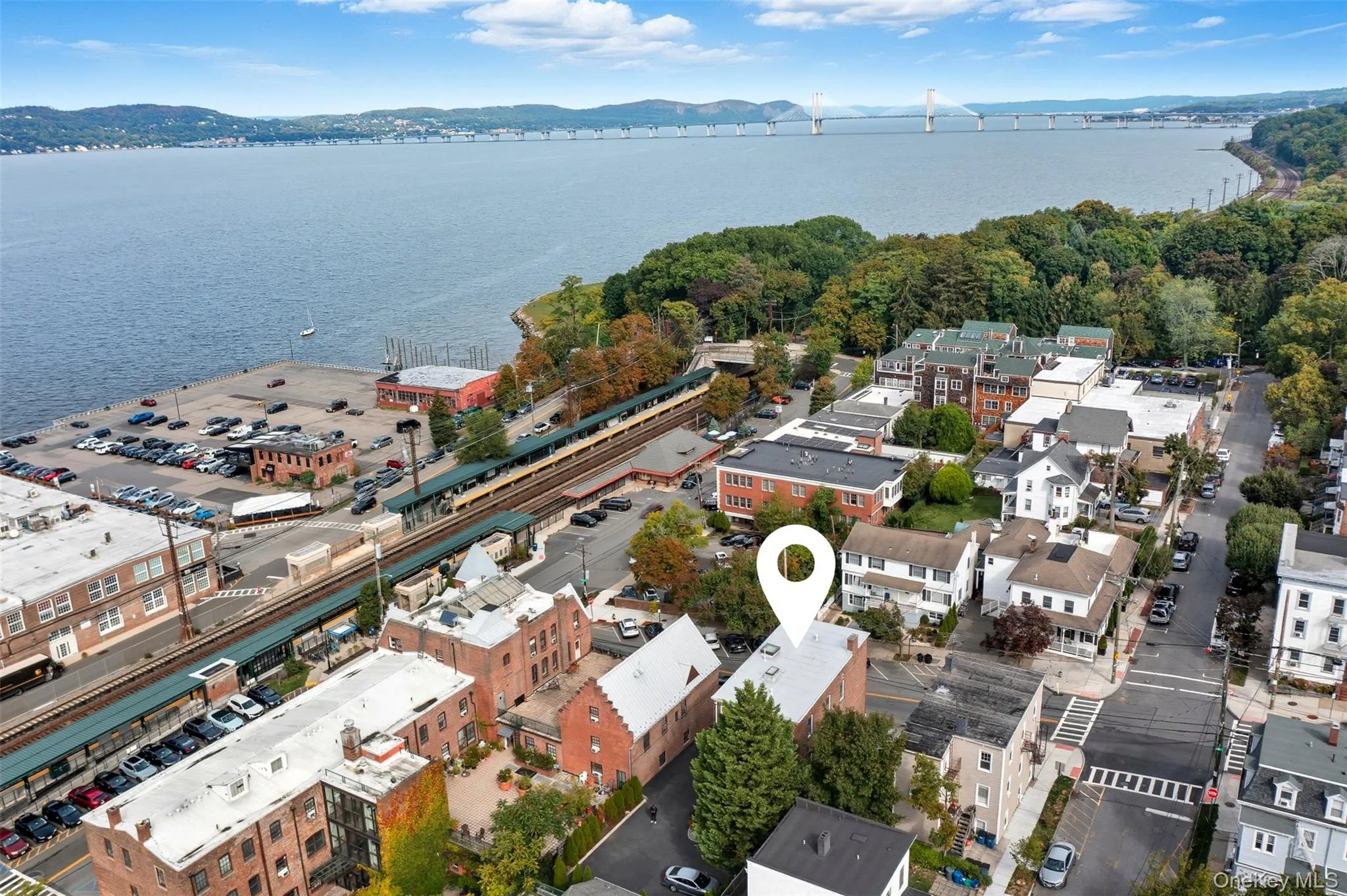 Aerial perspective showcasing a waterfront community with a prominent bridge structure and expansive water body Aerial perspective showcasing a waterfront community with a prominent bridge structure and expansive water body