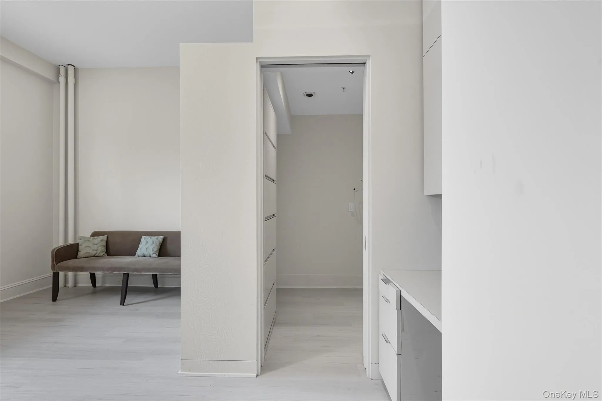 Integrated storage solutions featuring flat-panel cabinetry and a light-toned countertop Integrated storage solutions featuring flat-panel cabinetry and a light-toned countertop