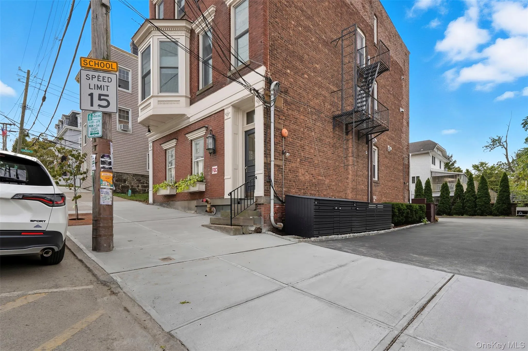 Brick facade building featuring a prominent bay window with window boxes Brick facade building featuring a prominent bay window with window boxes