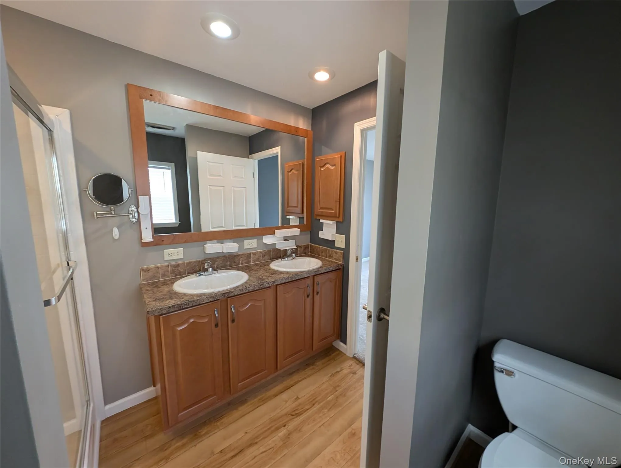 Bathroom featuring wood-type flooring, vanity, and toilet Bathroom featuring wood-type flooring, vanity, and toilet
