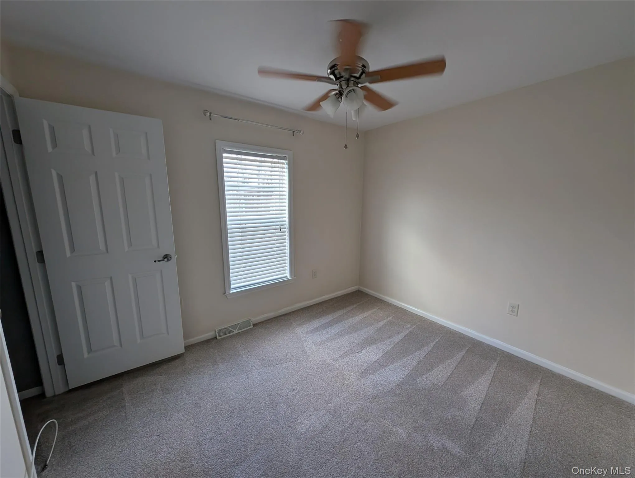 Carpeted empty room with ceiling fan Carpeted empty room with ceiling fan