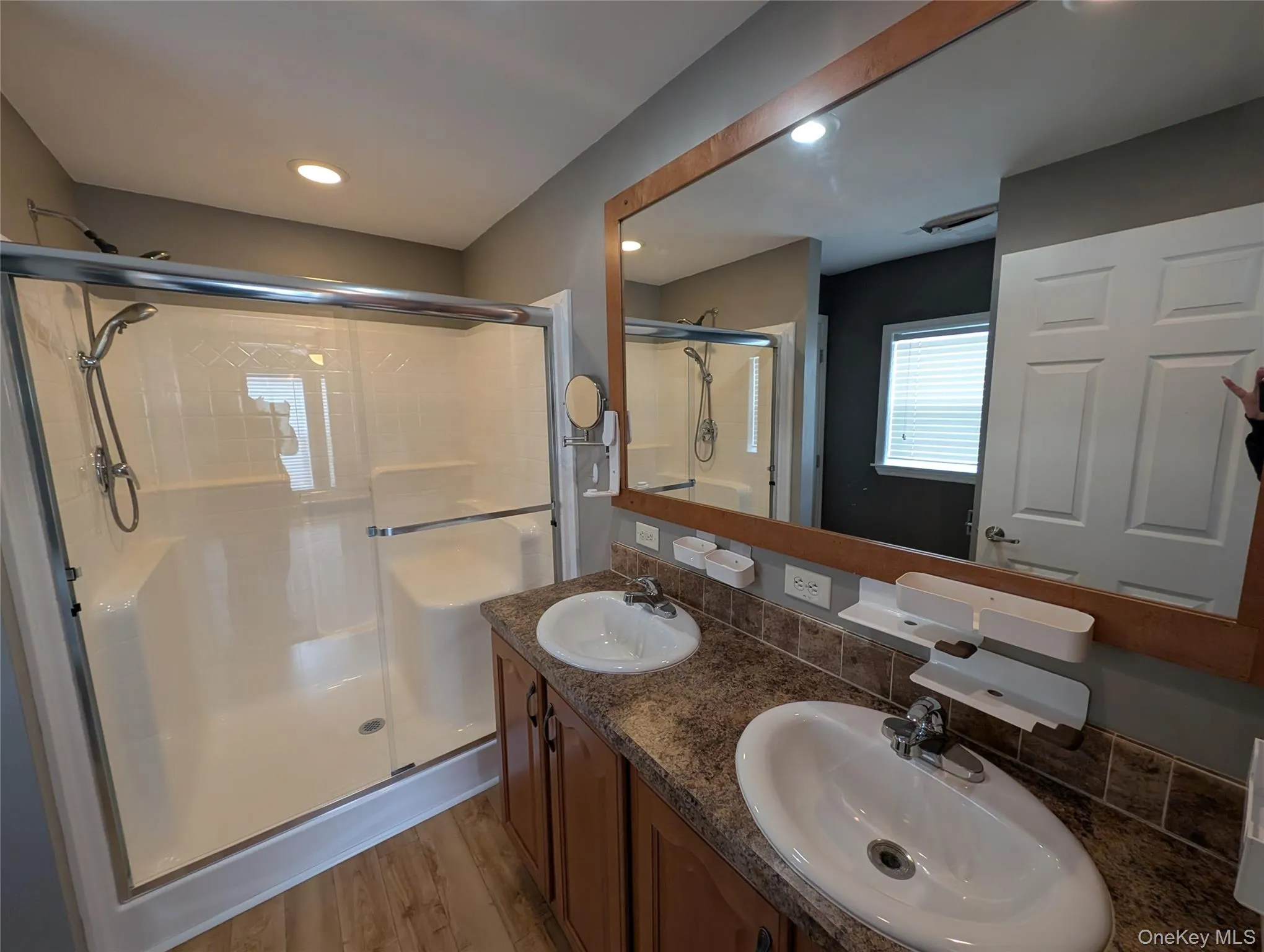 Bathroom featuring walk in shower, vanity, and hardwood / wood-style flooring Bathroom featuring walk in shower, vanity, and hardwood / wood-style flooring