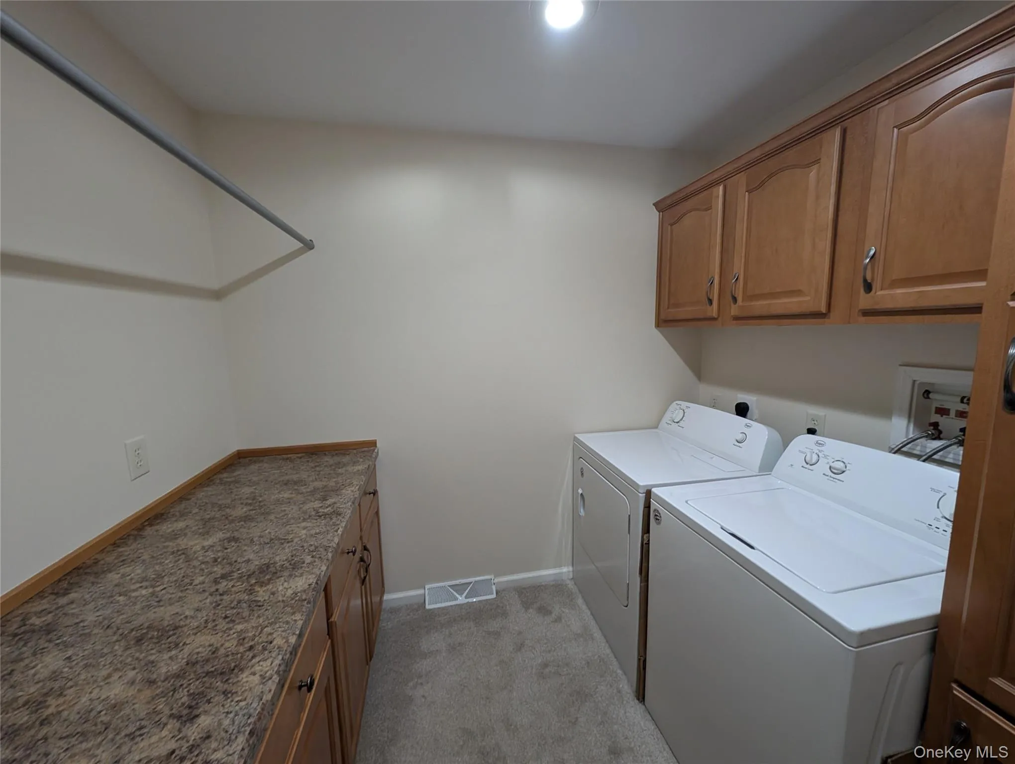 Laundry area with washer and dryer, cabinets, and light carpet Laundry area with washer and dryer, cabinets, and light carpet