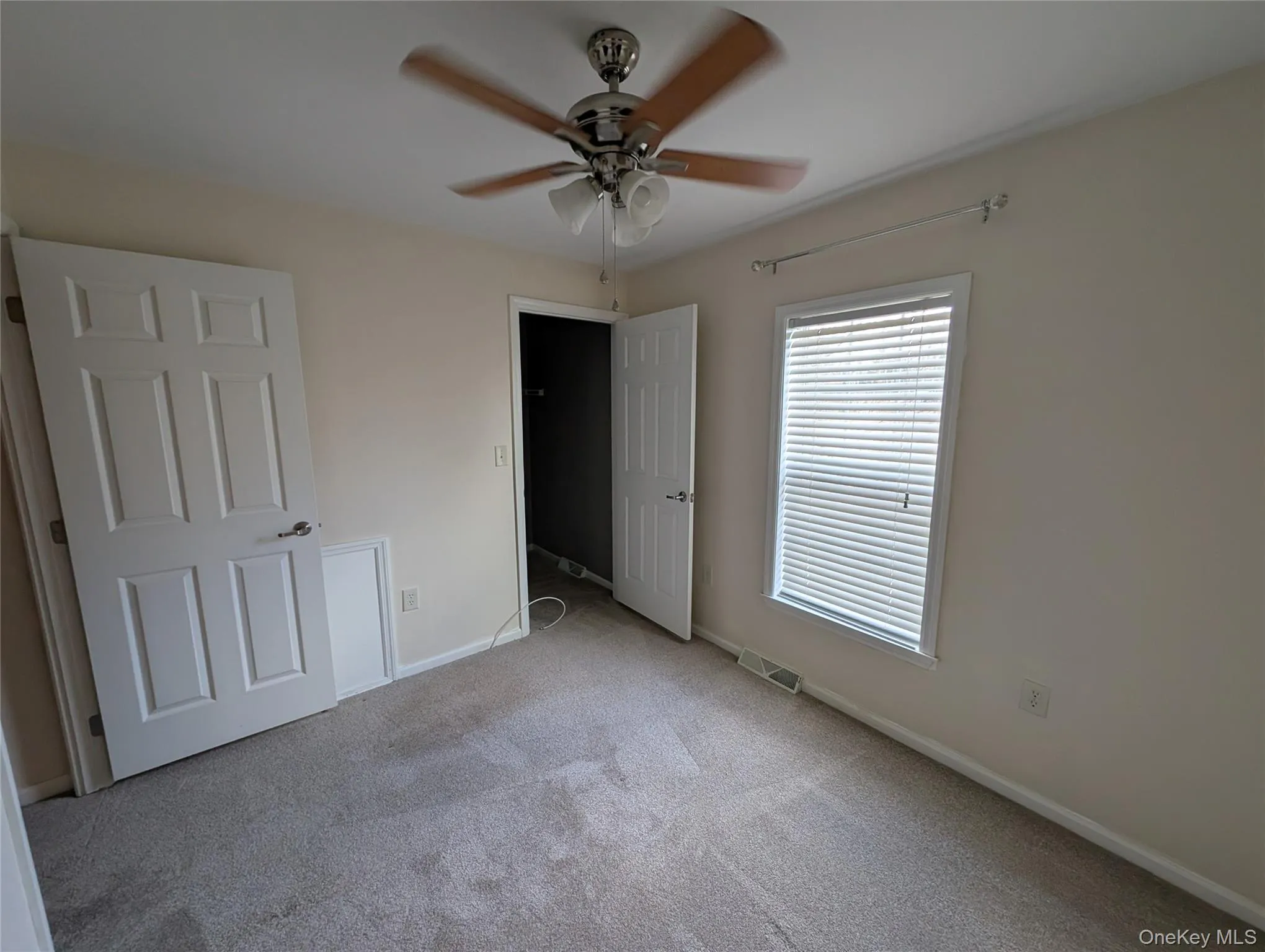 Unfurnished bedroom featuring ceiling fan and light carpet Unfurnished bedroom featuring ceiling fan and light carpet