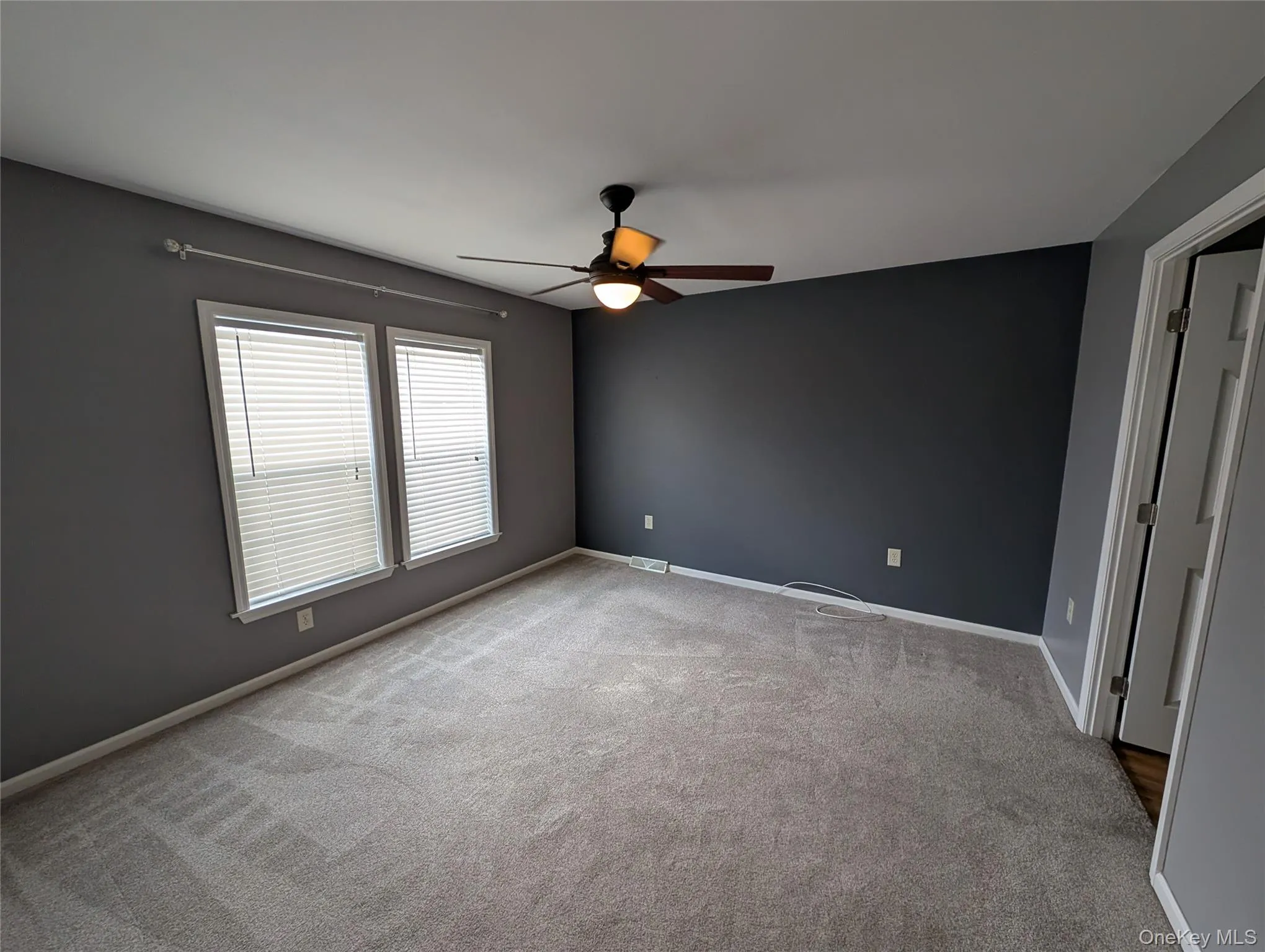 Unfurnished room with light carpet and ceiling fan Unfurnished room with light carpet and ceiling fan