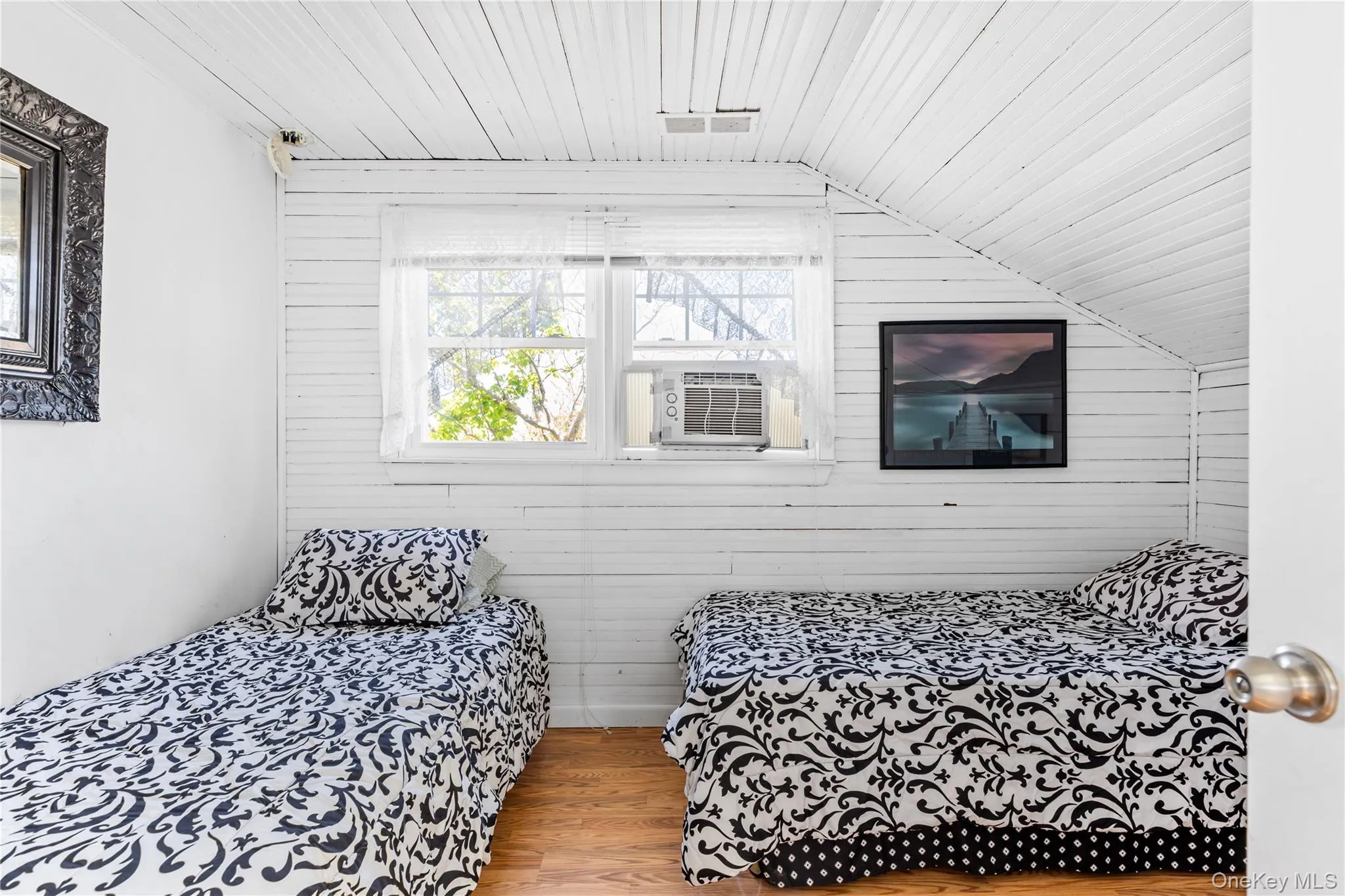White-painted wood-plank walls and ceiling with sloped architectural detail White-painted wood-plank walls and ceiling with sloped architectural detail
