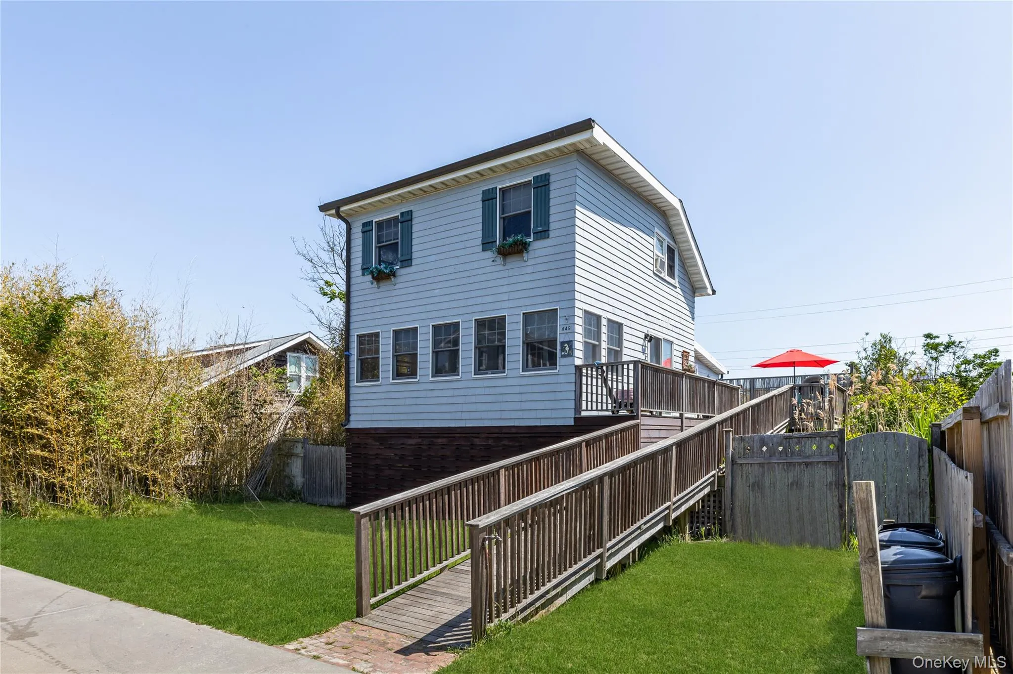 light blue siding, a multi-level wooden deck, and a wooden access ramp light blue siding, a multi-level wooden deck, and a wooden access ramp