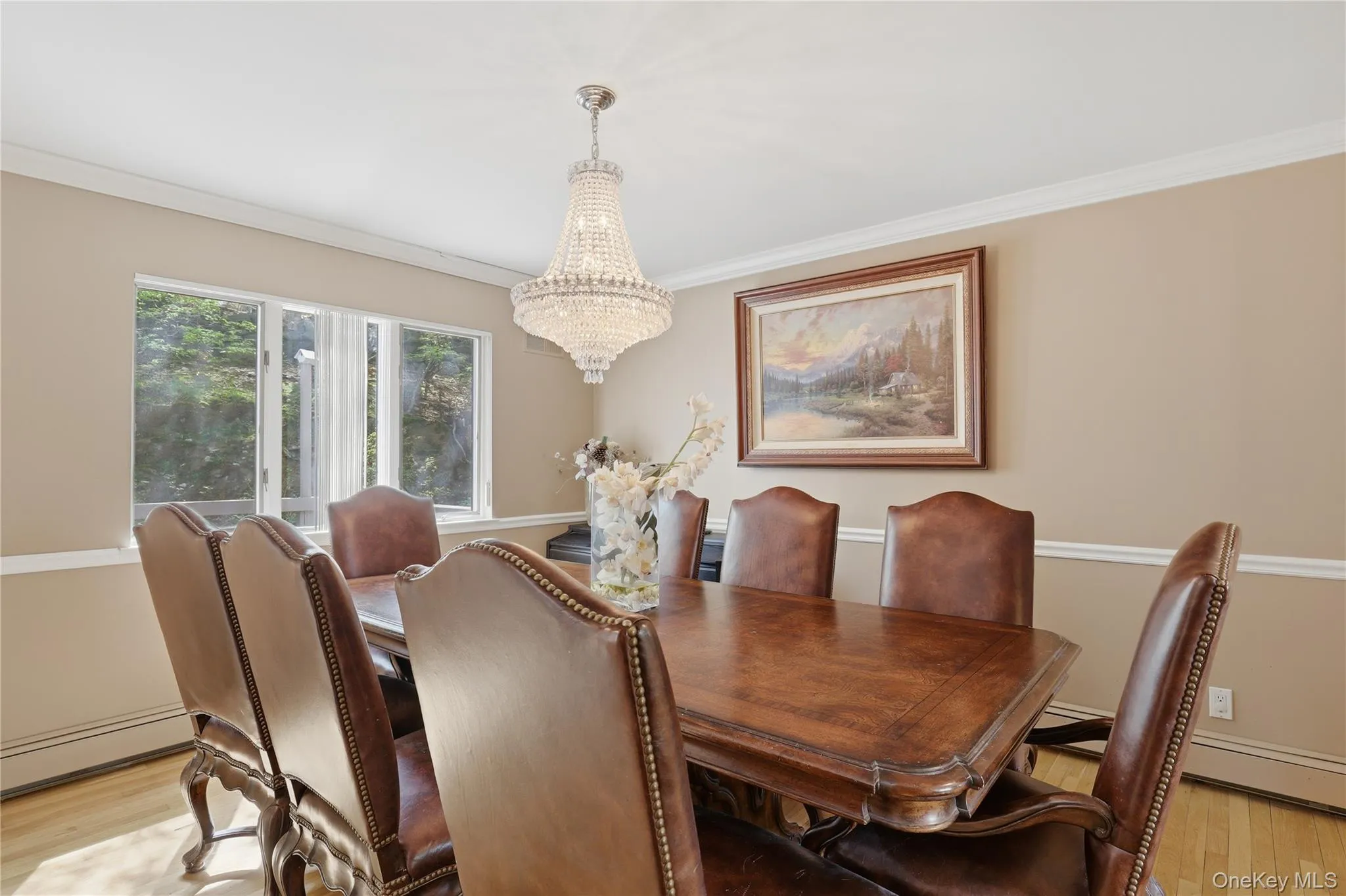 Dining area with hardwood-style flooring, a multi-panel window, and crown molding Dining area with hardwood-style flooring, a multi-panel window, and crown molding