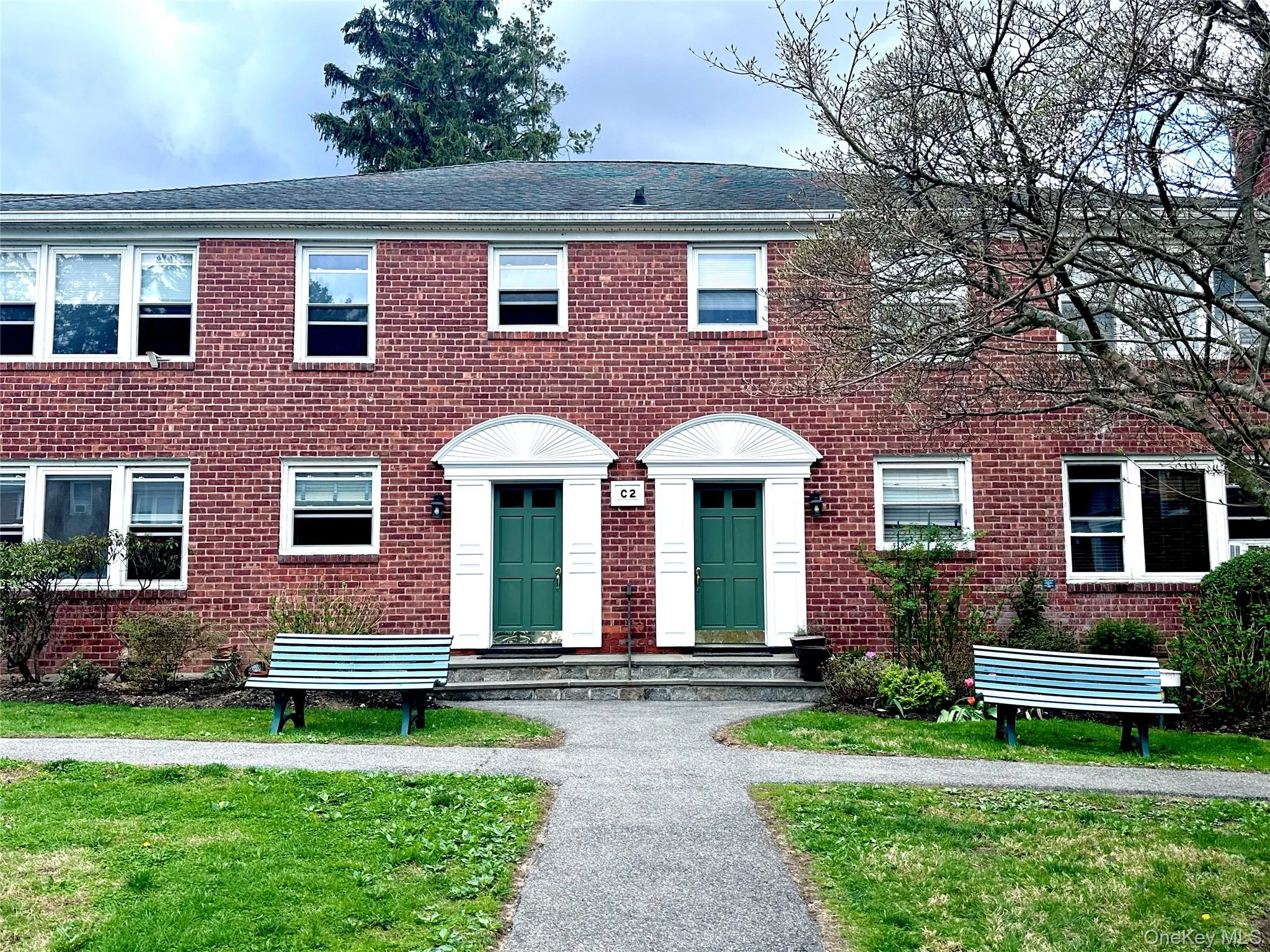 Brick exterior featuring two arched entryways with green panel doors Brick exterior featuring two arched entryways with green panel doors