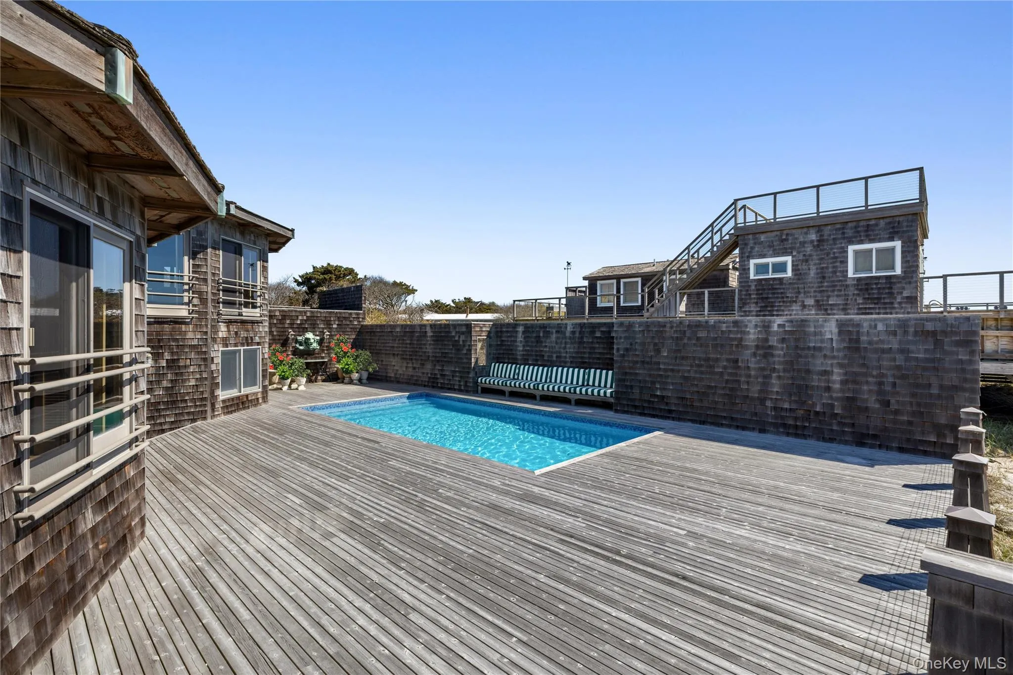 Facing the expansive deck area with the pool and seating area in view Facing the expansive deck area with the pool and seating area in view