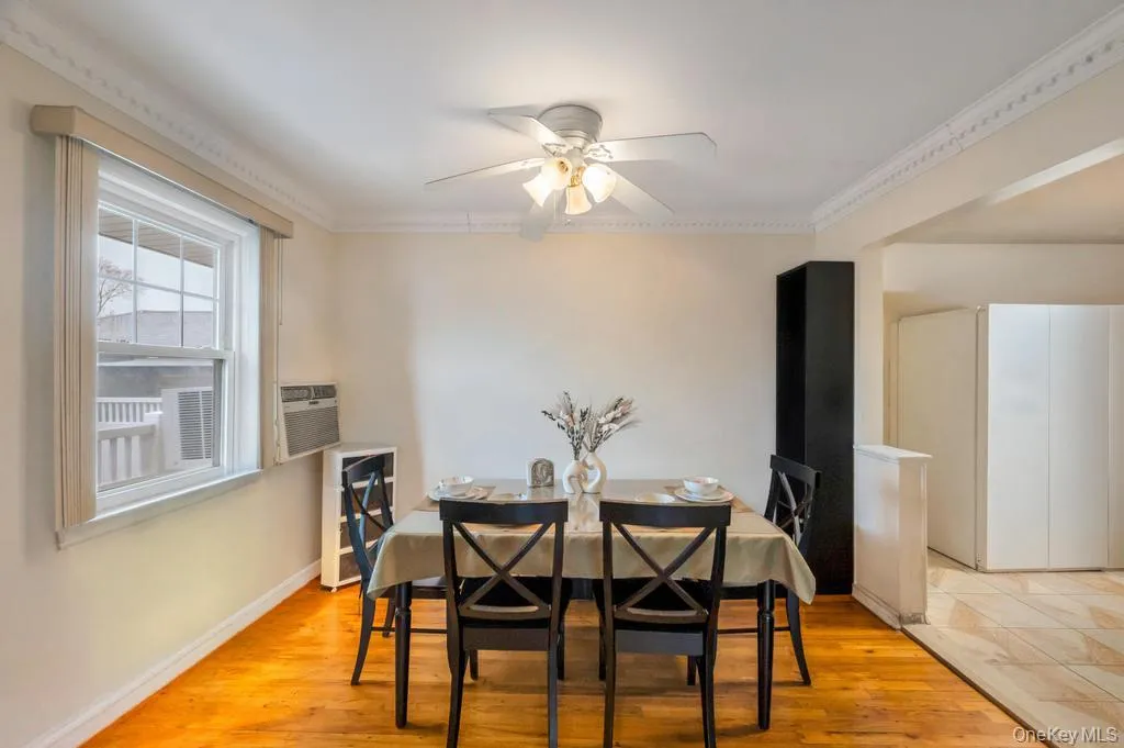 Dining area featuring wood-finish flooring, a ceiling fan, and crown molding Dining area featuring wood-finish flooring, a ceiling fan, and crown molding