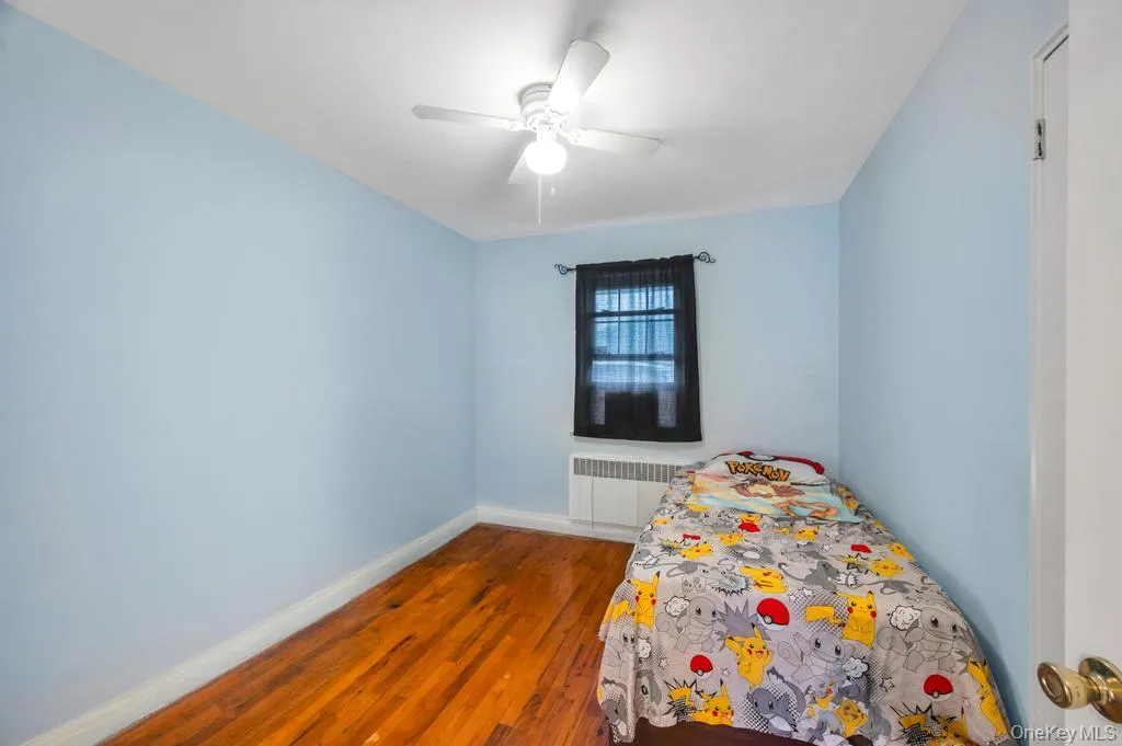 Room featuring wood-finish flooring, light blue walls, and a white ceiling Room featuring wood-finish flooring, light blue walls, and a white ceiling