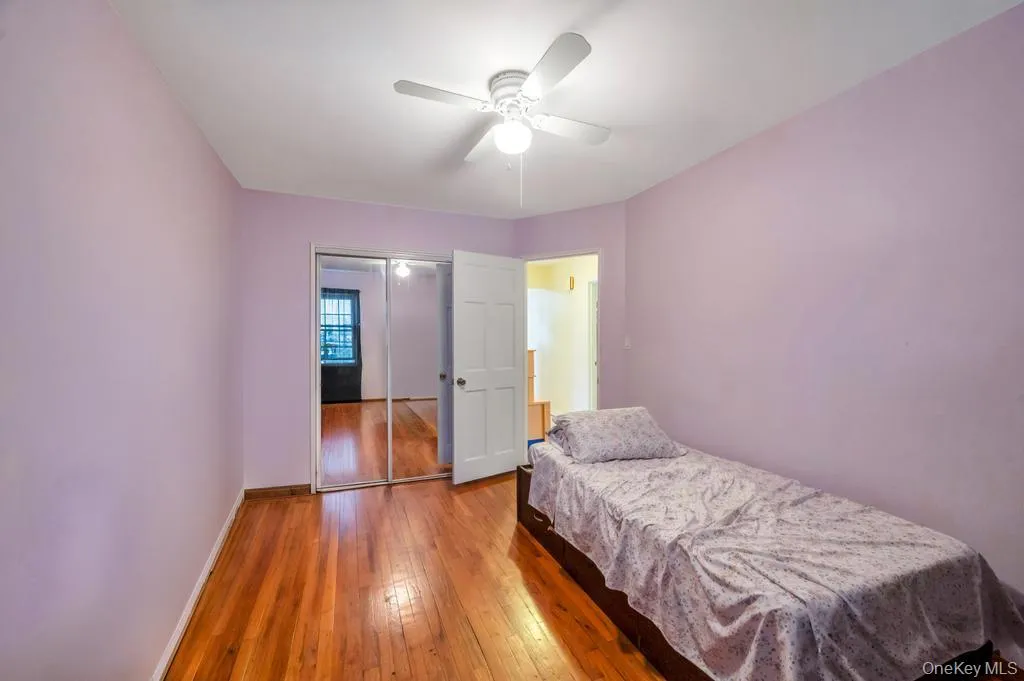 Hardwood flooring throughout featuring a ceiling fan, white trim, and mirrored closet doors Hardwood flooring throughout featuring a ceiling fan, white trim, and mirrored closet doors