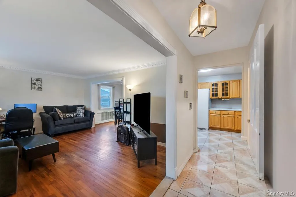 Hardwood-finish flooring in the living area, illuminated by natural light from a window Hardwood-finish flooring in the living area, illuminated by natural light from a window