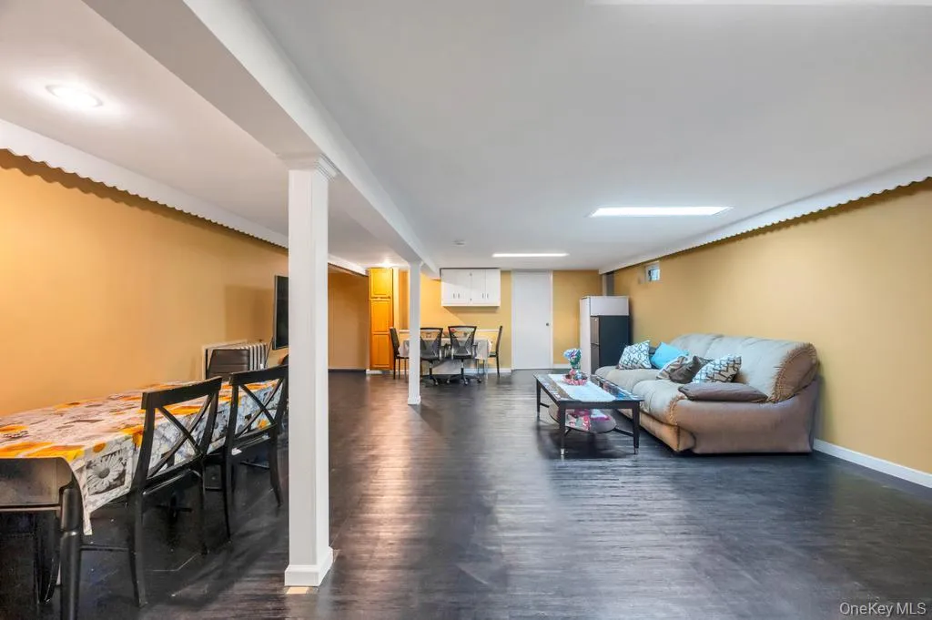 Spacious lower level featuring dark wood-finish flooring, recessed lighting, and support columns Spacious lower level featuring dark wood-finish flooring, recessed lighting, and support columns