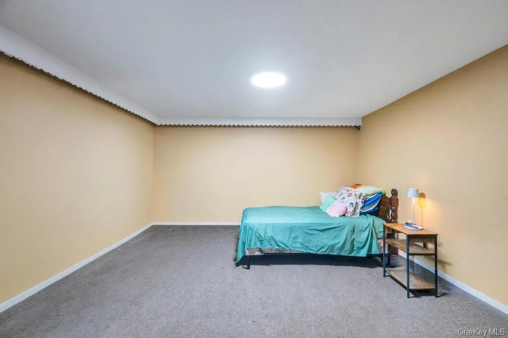 Carpeted room with a circular ceiling light fixture, crown molding, and neutral-toned walls Carpeted room with a circular ceiling light fixture, crown molding, and neutral-toned walls