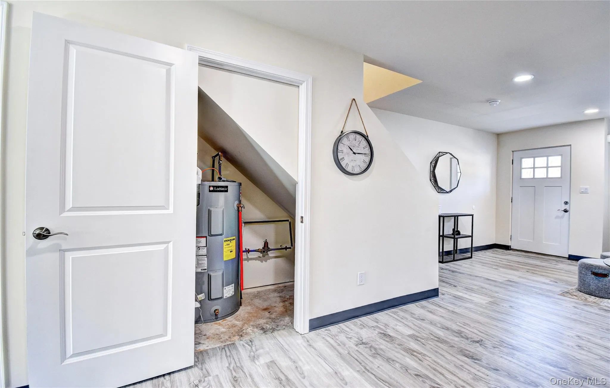 Entryway with light hardwood / wood-style flooring and electric water heater Entryway with light hardwood / wood-style flooring and electric water heater
