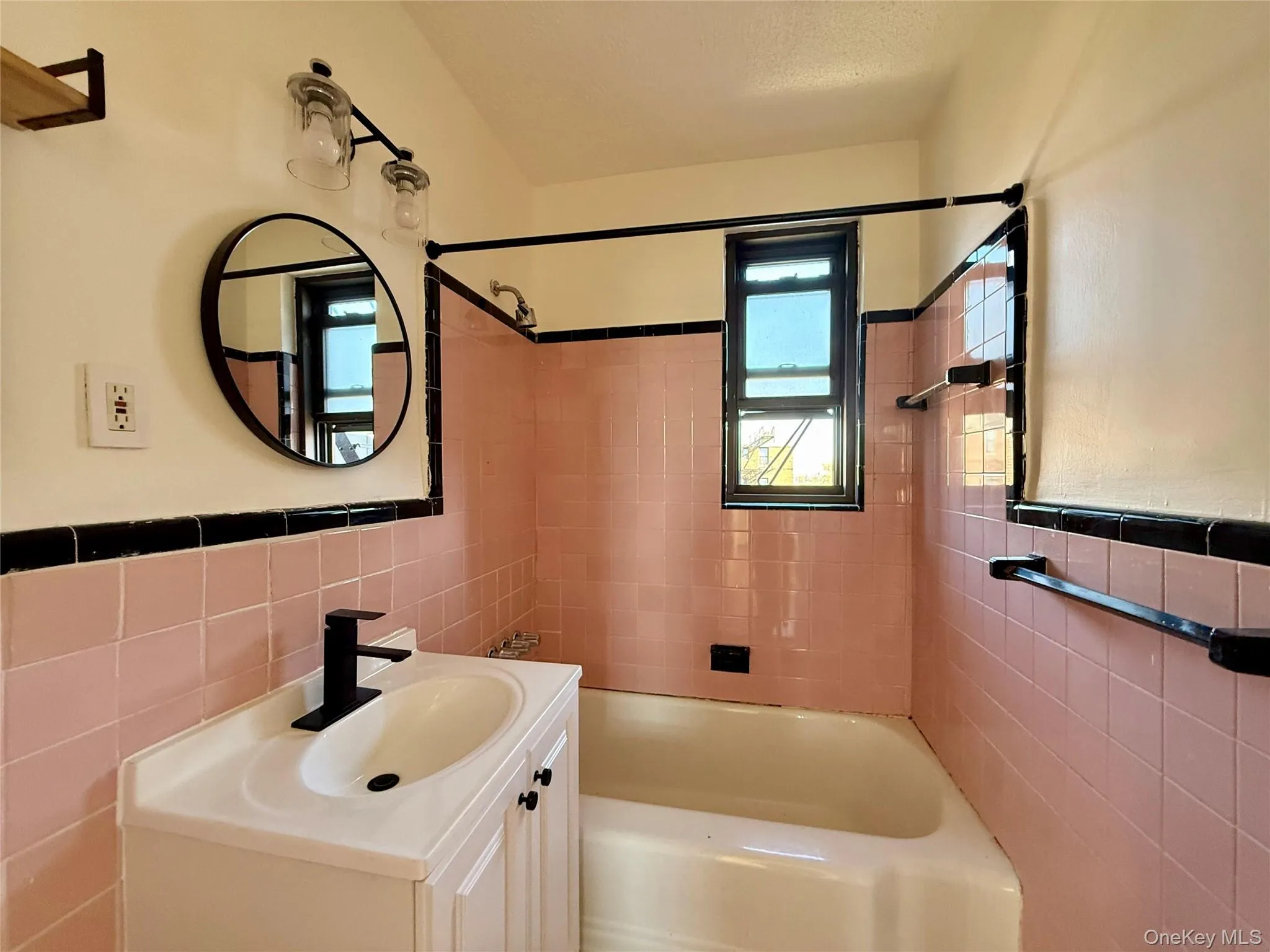 Original bathroom with updated sink, lights and mirror. Window for ventilation, tile on the floors and walls. Original bathroom with updated sink, lights and mirror. Window for ventilation, tile on the floors and walls.