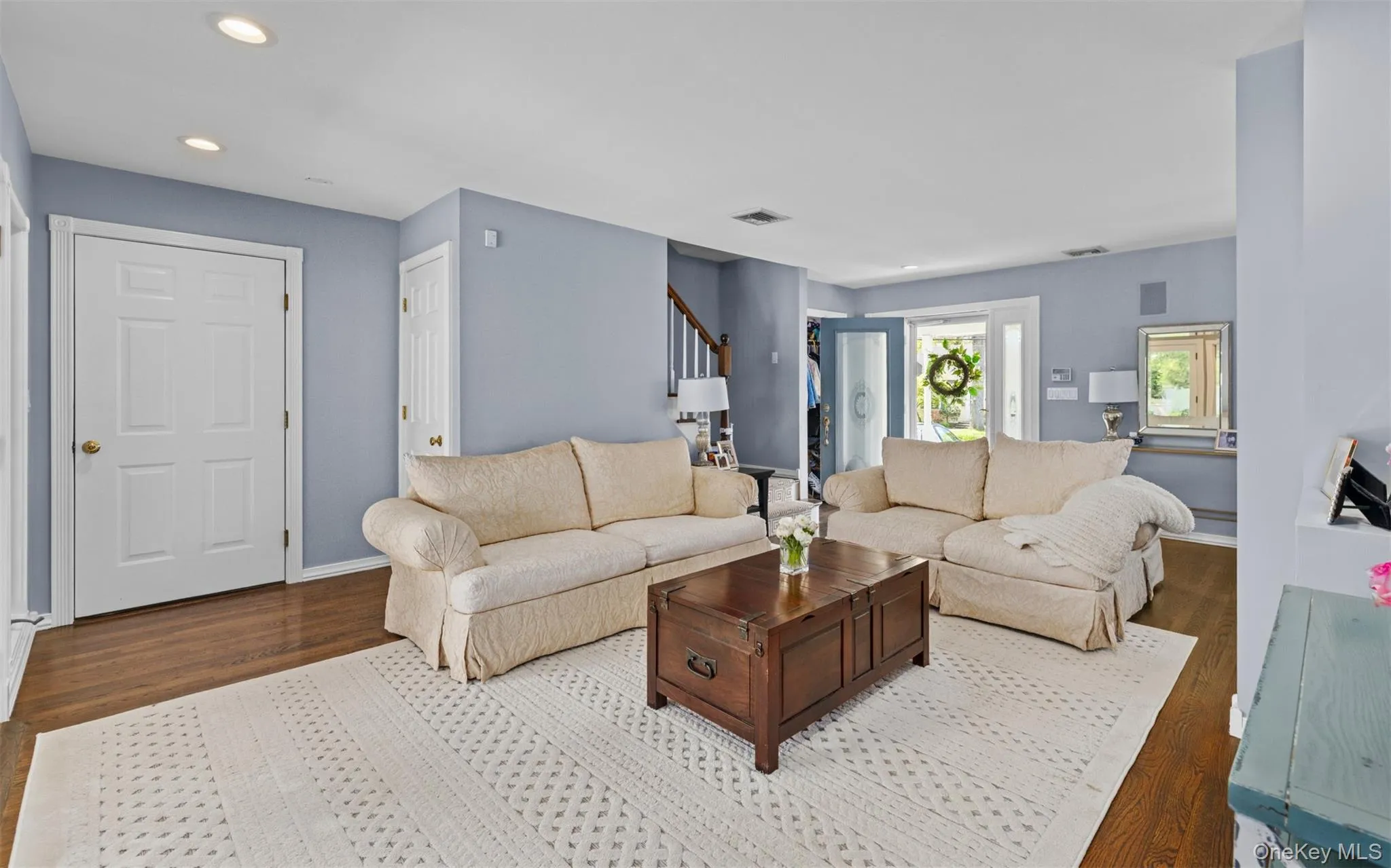Living room featuring wood flooring, light blue wall paint, recessed lighting, and white trim Living room featuring wood flooring, light blue wall paint, recessed lighting, and white trim