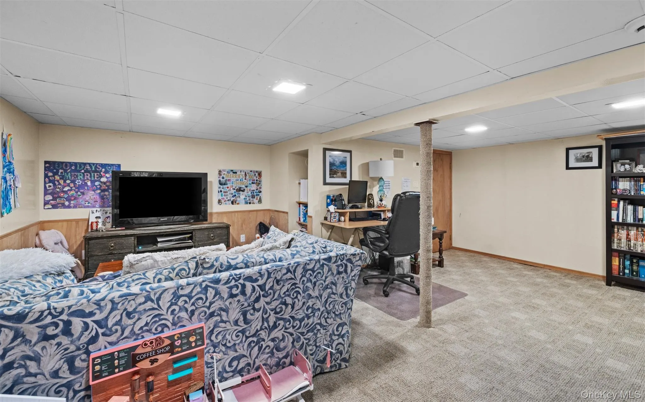 Carpeted lower-level space featuring a drop ceiling with recessed lighting Carpeted lower-level space featuring a drop ceiling with recessed lighting