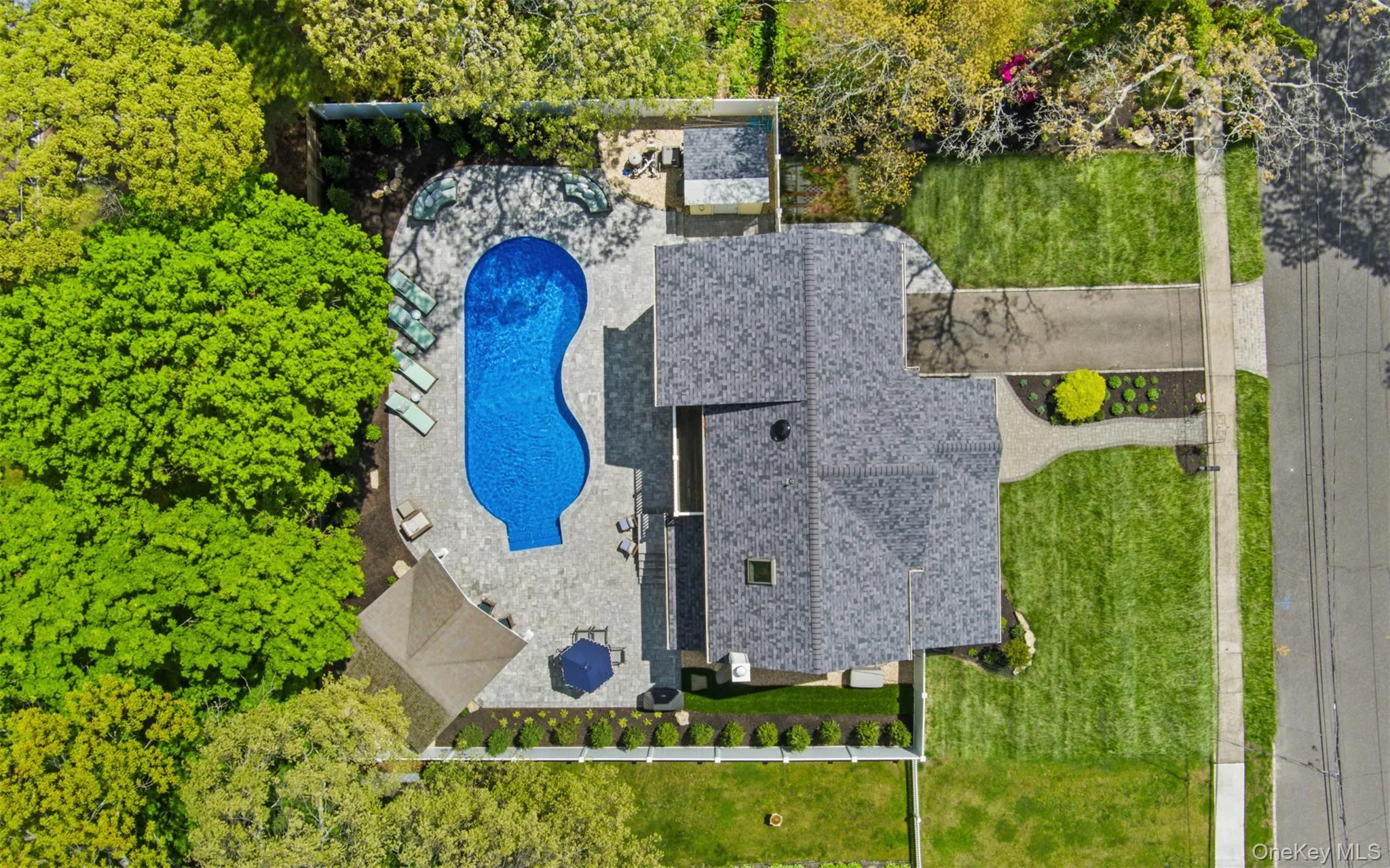 This property features a free form in-ground pool surrounded by paver patio surfacing, and structured landscaping This property features a free form in-ground pool surrounded by paver patio surfacing, and structured landscaping