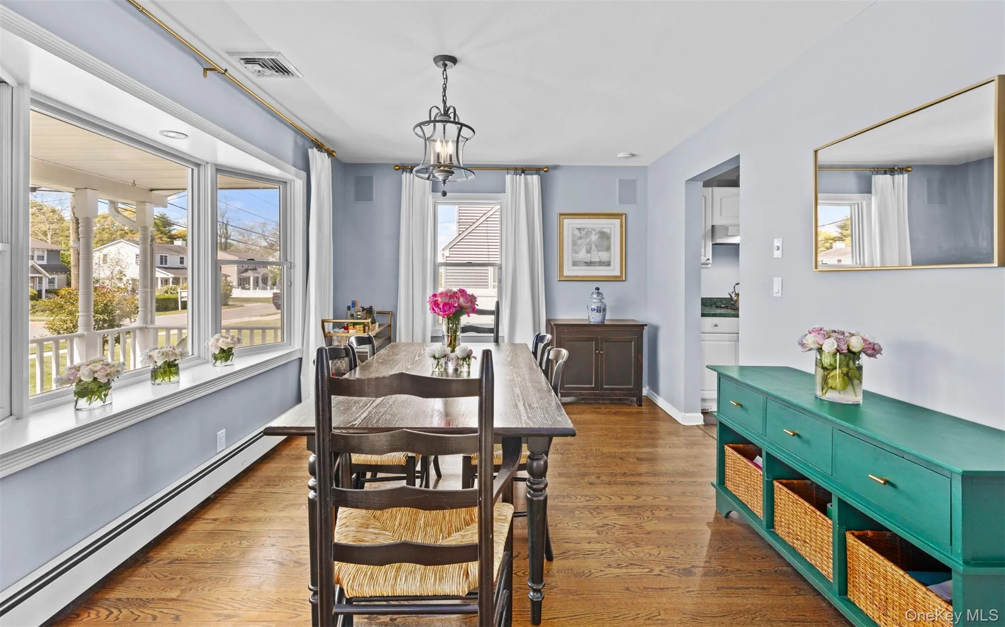 Dining room featuring wood flooring, a large bay window, and a light fixture Dining room featuring wood flooring, a large bay window, and a light fixture