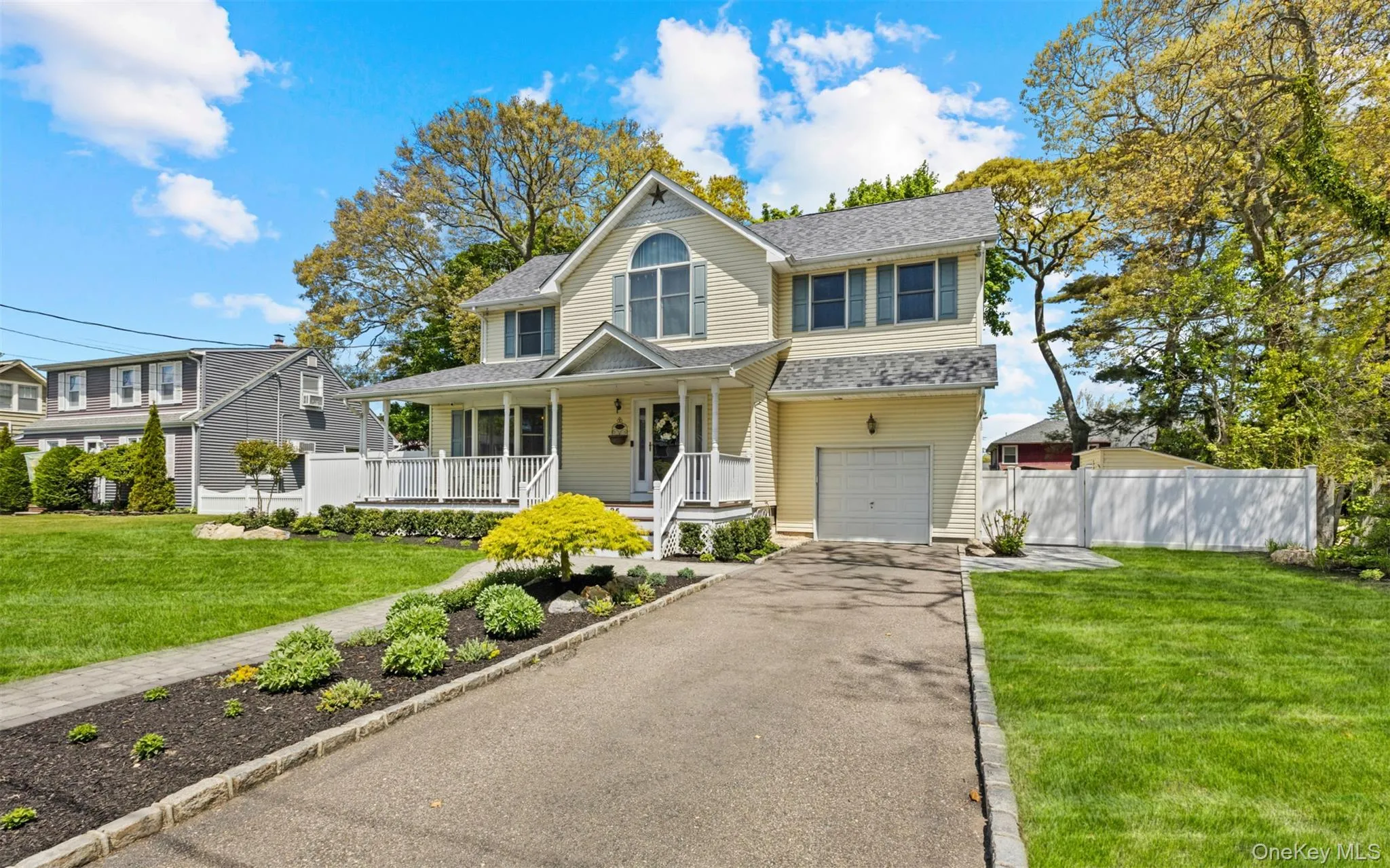 Traditional-style home featuring a covered front porch with white railings, a prominent arched window, and a single-car garage Traditional-style home featuring a covered front porch with white railings, a prominent arched window, and a single-car garage