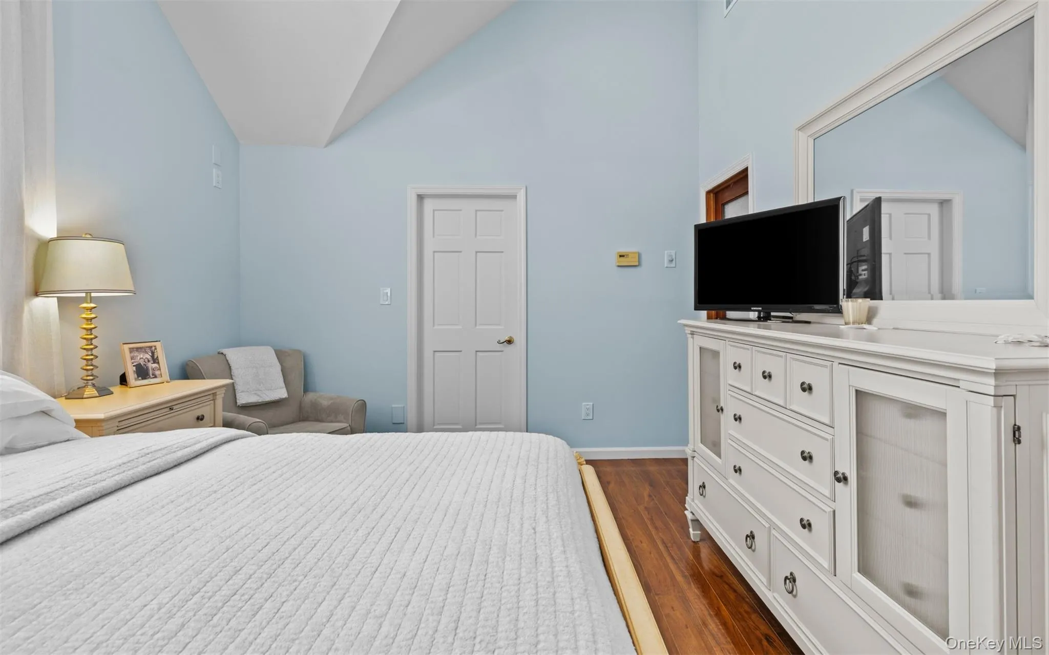 Vaulted cathedral ceiling bedroom with light blue walls and wood flooring Vaulted cathedral ceiling bedroom with light blue walls and wood flooring