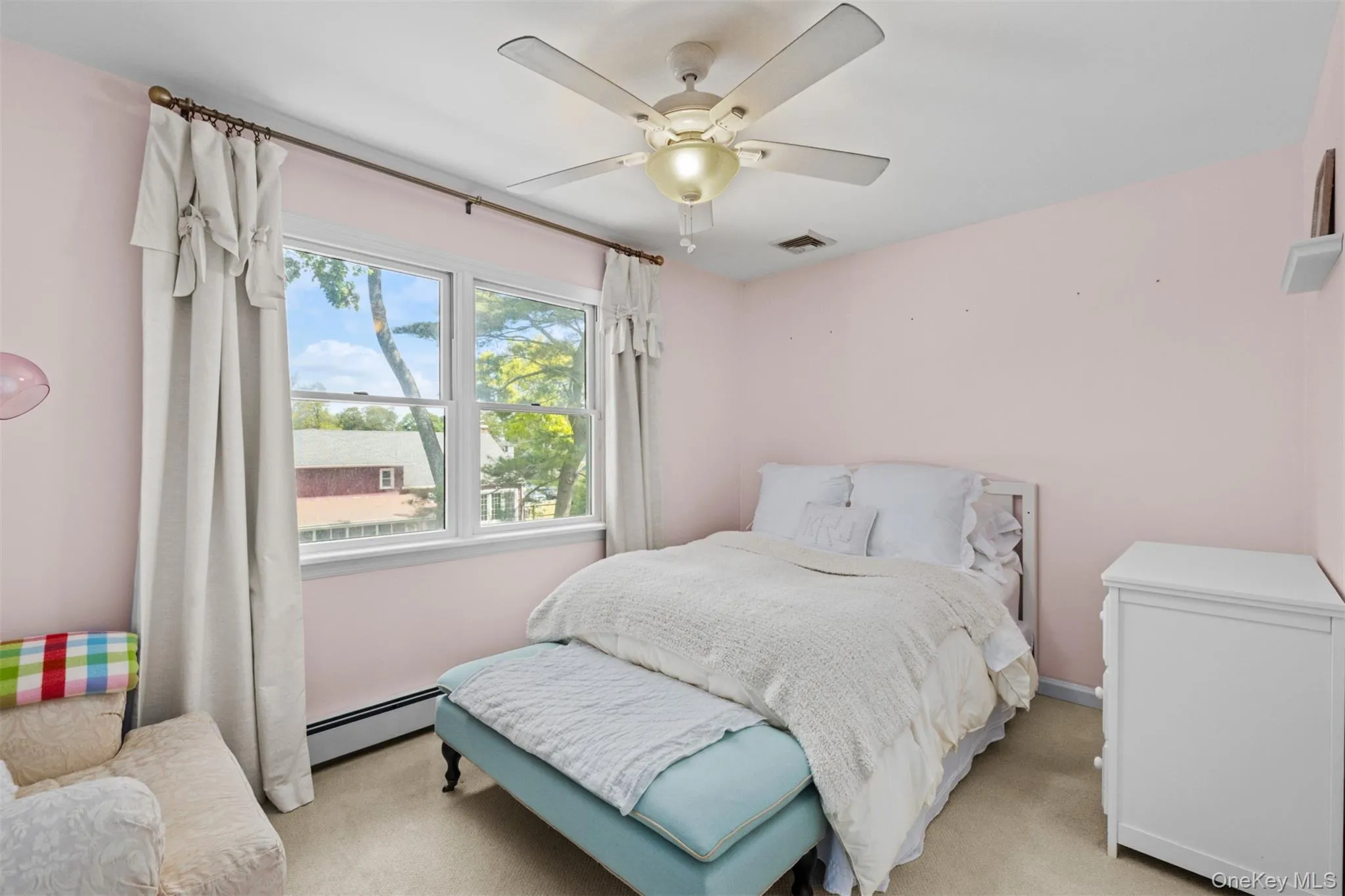 Second floor bedroom featuring a large window window, flush-mount ceiling fan, and light-toned carpeting Second floor bedroom featuring a large window window, flush-mount ceiling fan, and light-toned carpeting