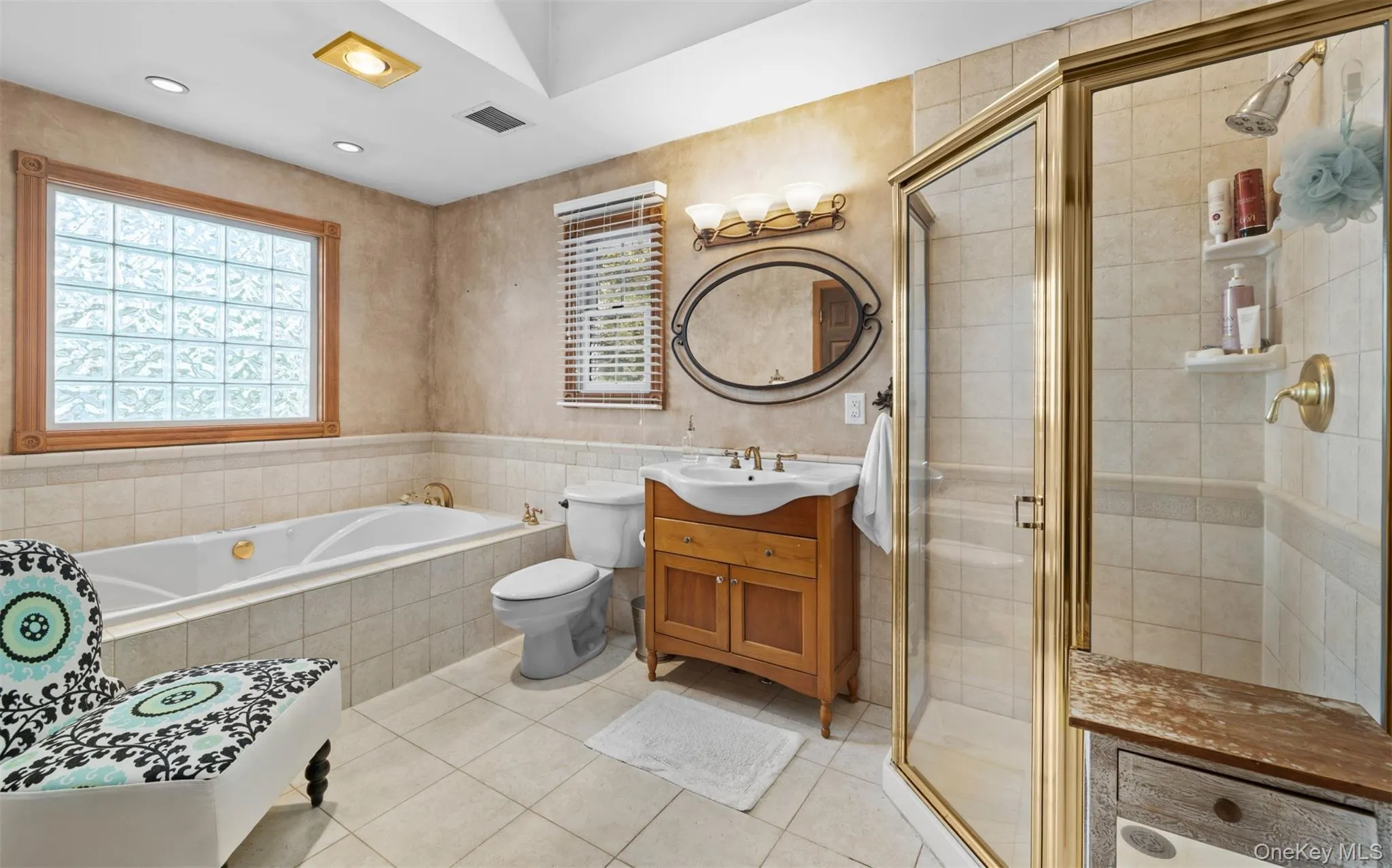 Primary full bathroom featuring a soaking tub, glass block window, and a separate shower enclosure Primary full bathroom featuring a soaking tub, glass block window, and a separate shower enclosure