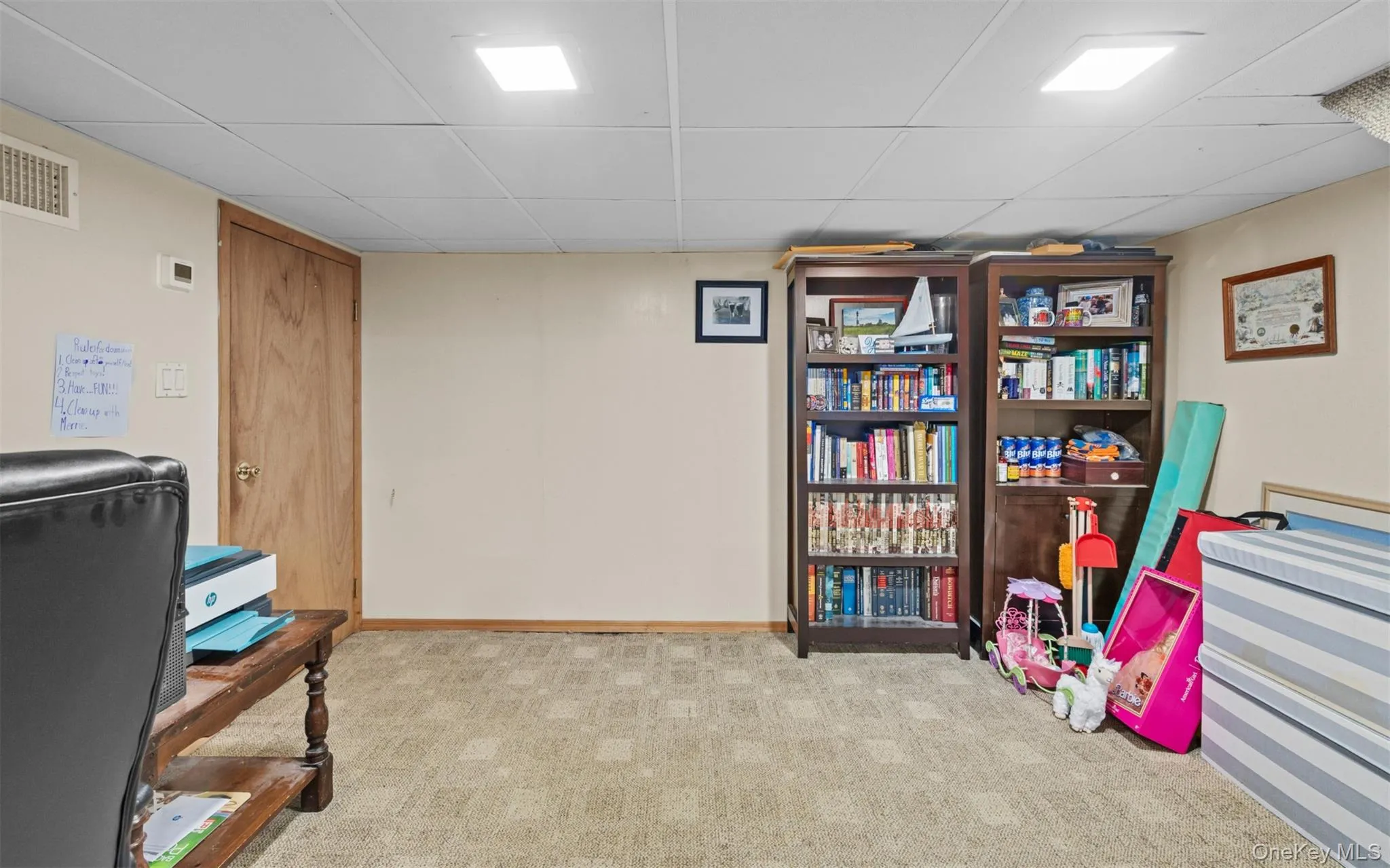 Carpeted lower-level space featuring a drop ceiling with recessed lighting Carpeted lower-level space featuring a drop ceiling with recessed lighting