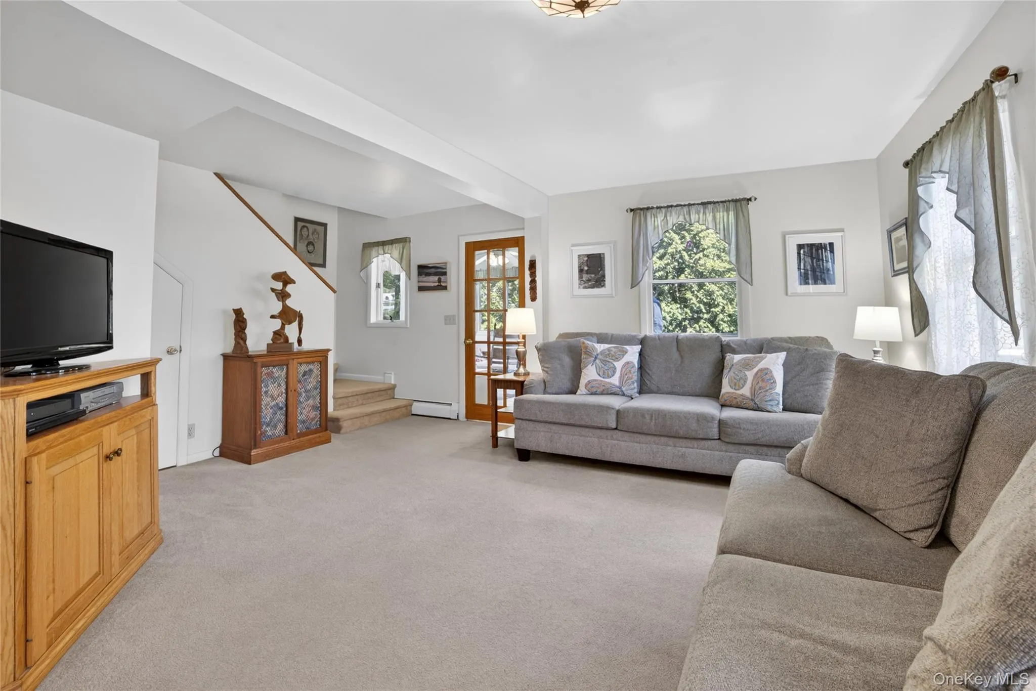 The living room with adjacent four season room and stairs to the second level. The living room with adjacent four season room and stairs to the second level.