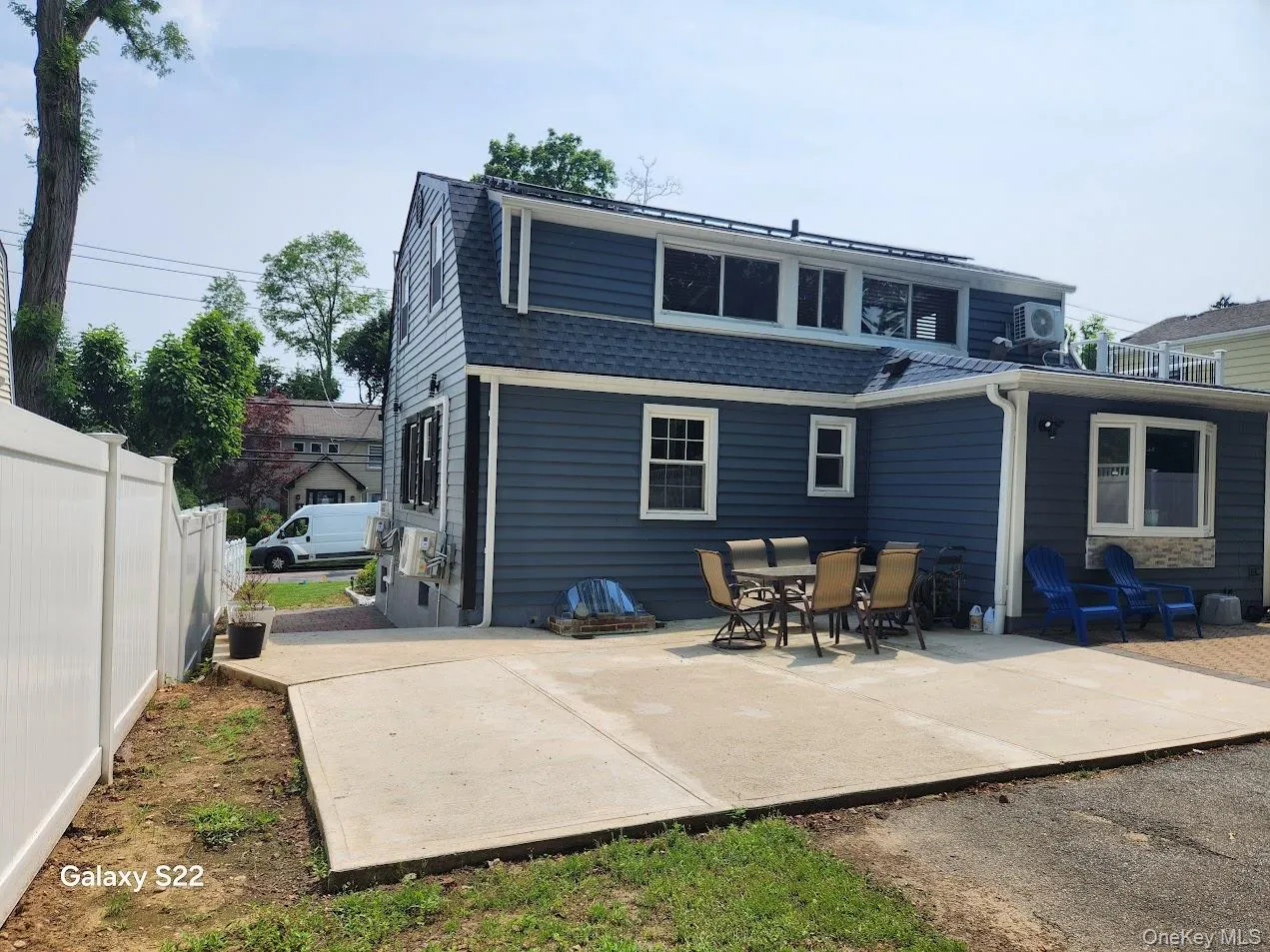 Rear view of property featuring a shingled roof and a patio area Rear view of property featuring a shingled roof and a patio area