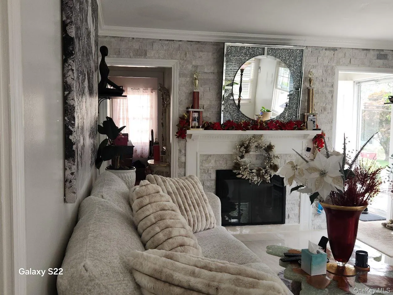 Living room featuring ornamental molding, healthy amount of natural light, and a glass covered fireplace Living room featuring ornamental molding, healthy amount of natural light, and a glass covered fireplace