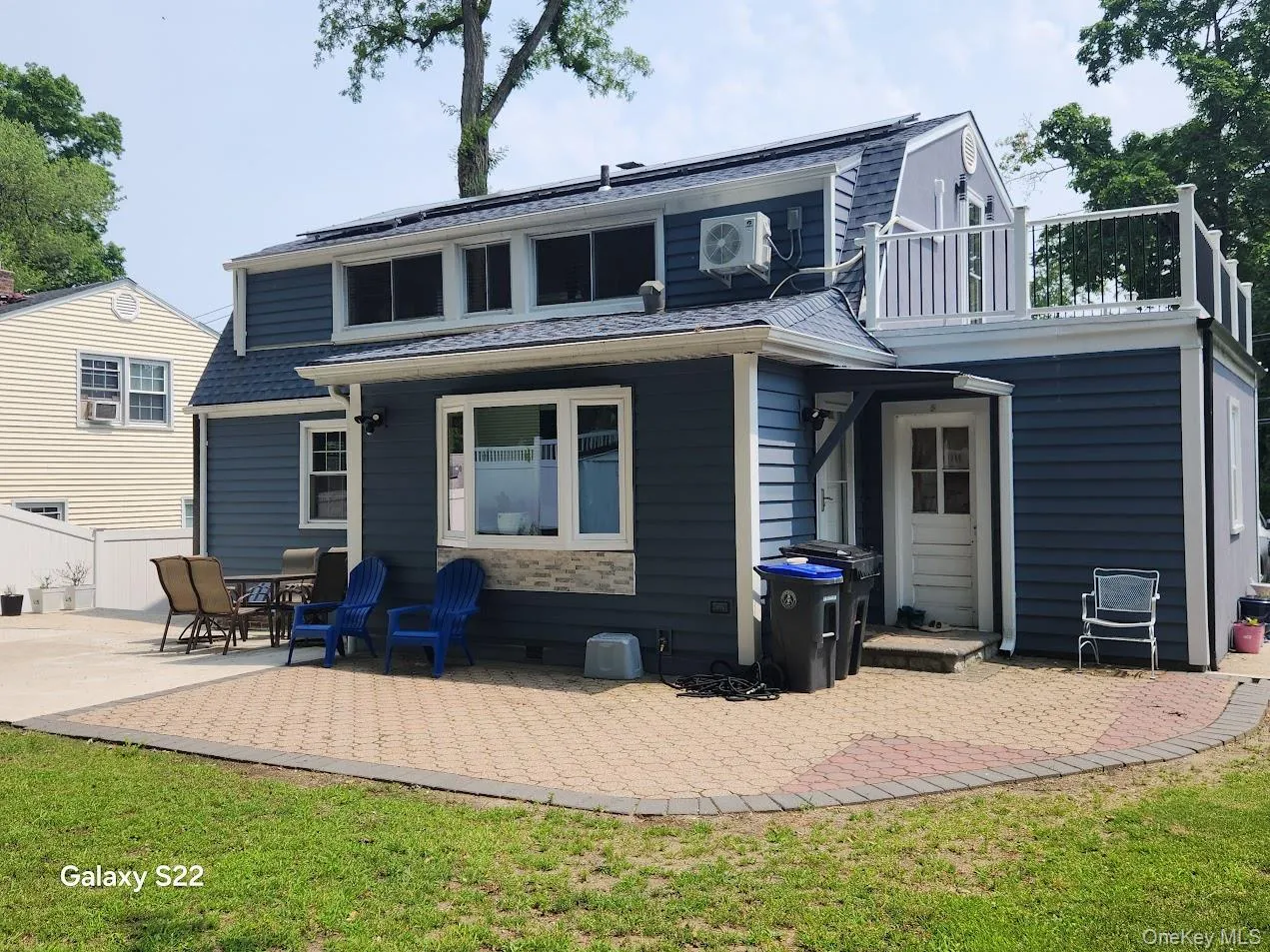 Rear view of property featuring a balcony, a patio, and a lawn Rear view of property featuring a balcony, a patio, and a lawn