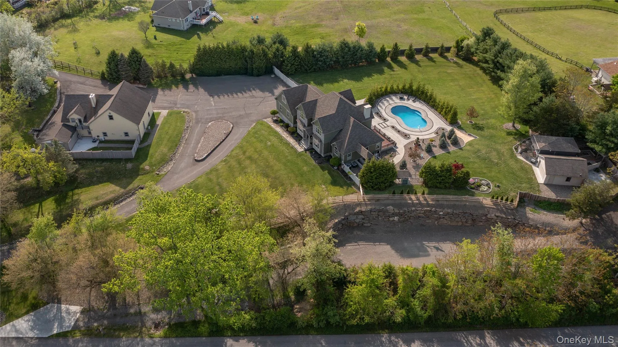 Aerial overview of property's location featuring a stunning pool complex with lush landscape Aerial overview of property's location featuring a stunning pool complex with lush landscape