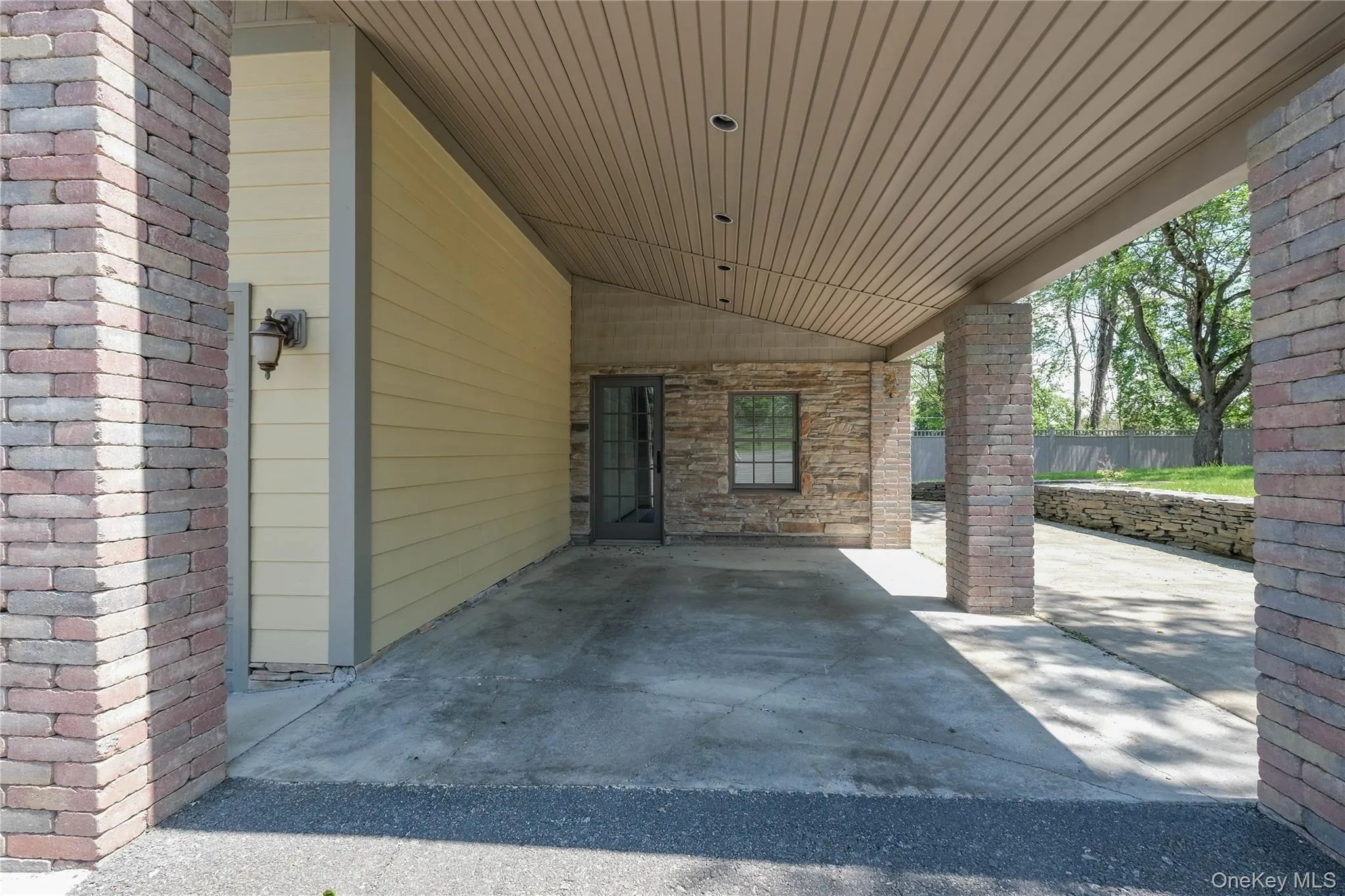 View of patio / terrace with a carport and landscaped side yard. View of patio / terrace with a carport and landscaped side yard.