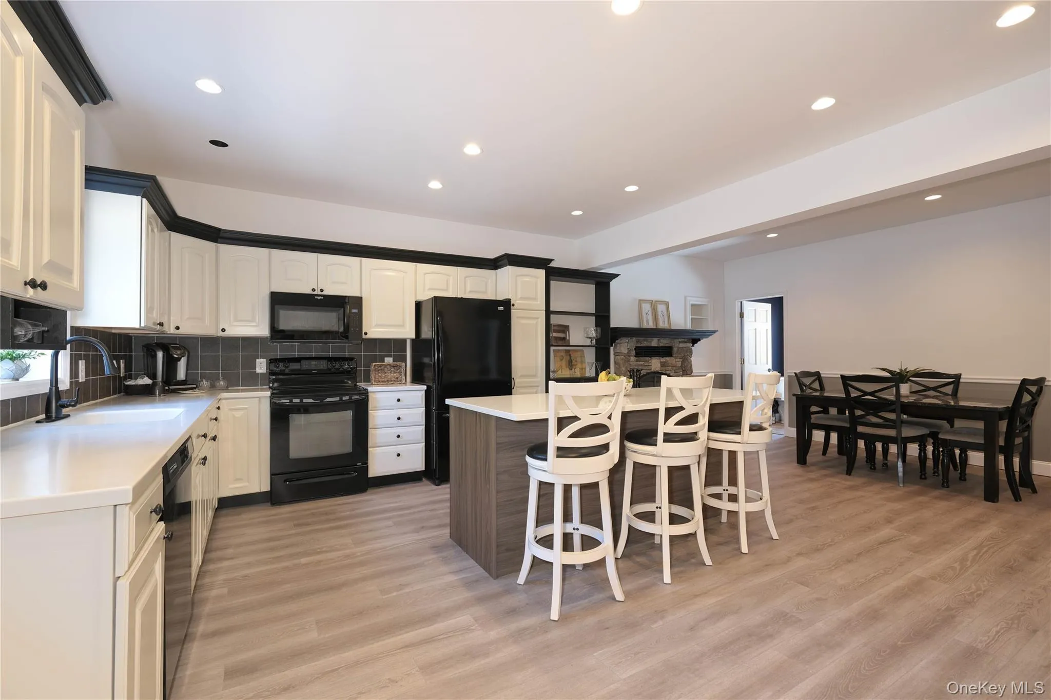Black appliances, floating island bar and tasteful backsplash. Black appliances, floating island bar and tasteful backsplash.