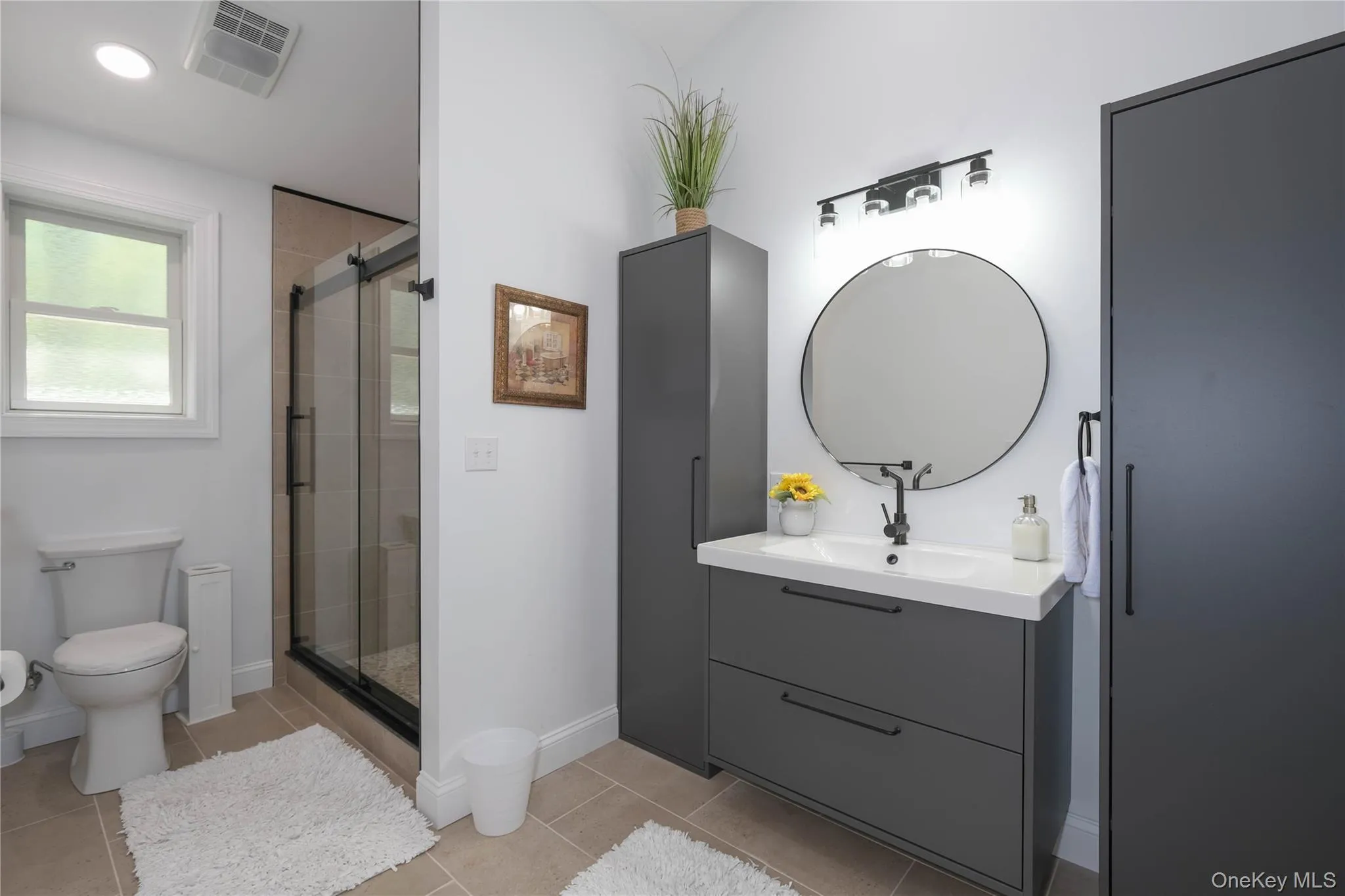 Full bath featuring tile floors, tiled and glass shower, and stylish vanity. Full bath featuring tile floors, tiled and glass shower, and stylish vanity.