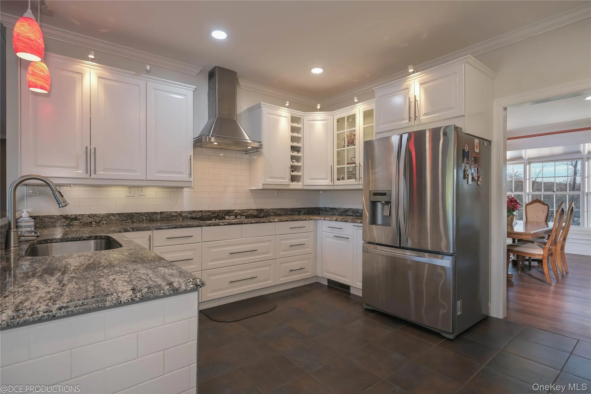 Kitchen featuring tile flooring, stainless appliance package, white cabinetry with ample storage and a stylish backsplash. Kitchen featuring tile flooring, stainless appliance package, white cabinetry with ample storage and a stylish backsplash.