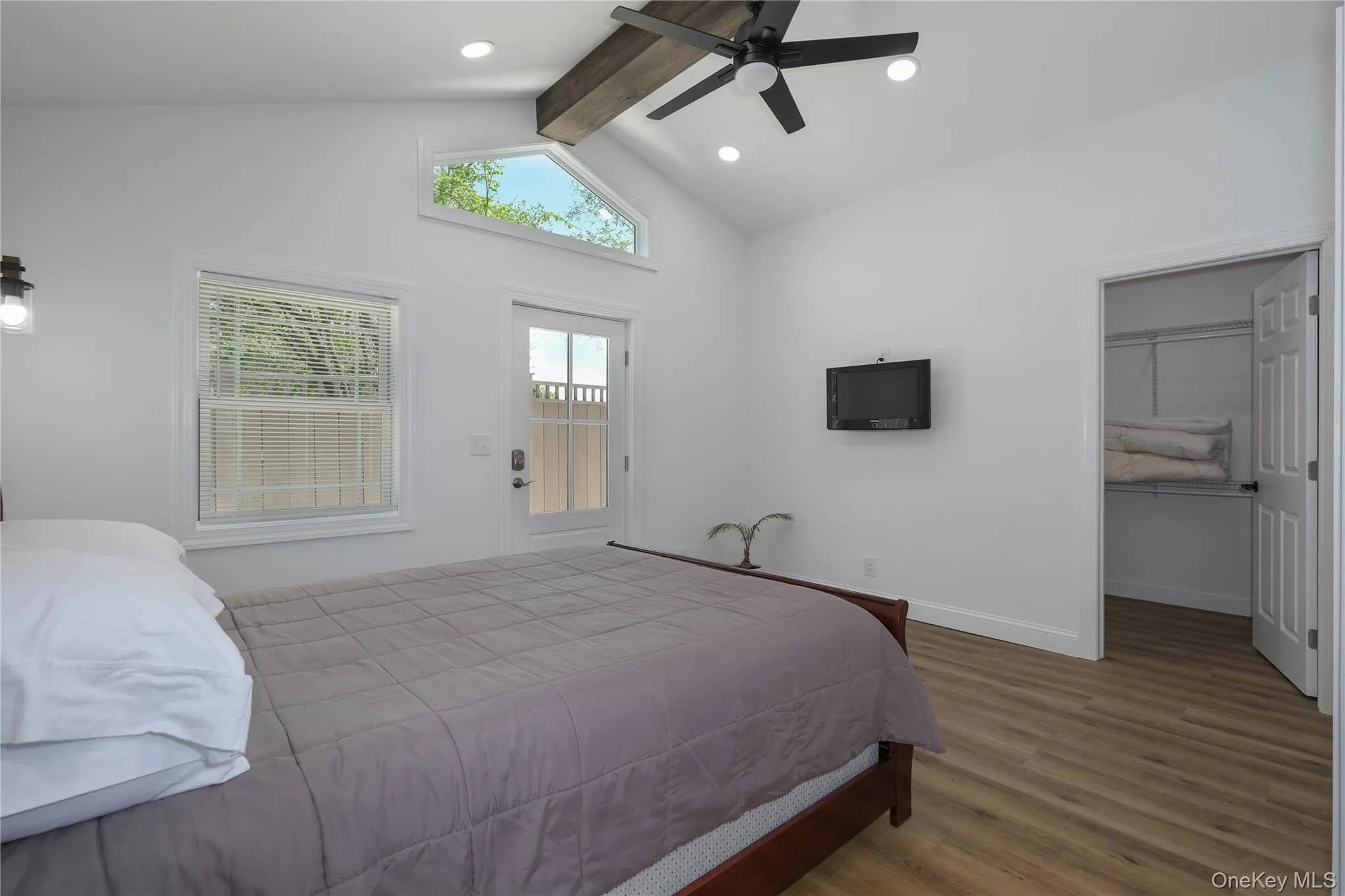 Main level bedroom with gleaming floors, a spacious closet, ceiling fan, recessed lighting and direct access to rear fenced patio. Main level bedroom with gleaming floors, a spacious closet, ceiling fan, recessed lighting and direct access to rear fenced patio.