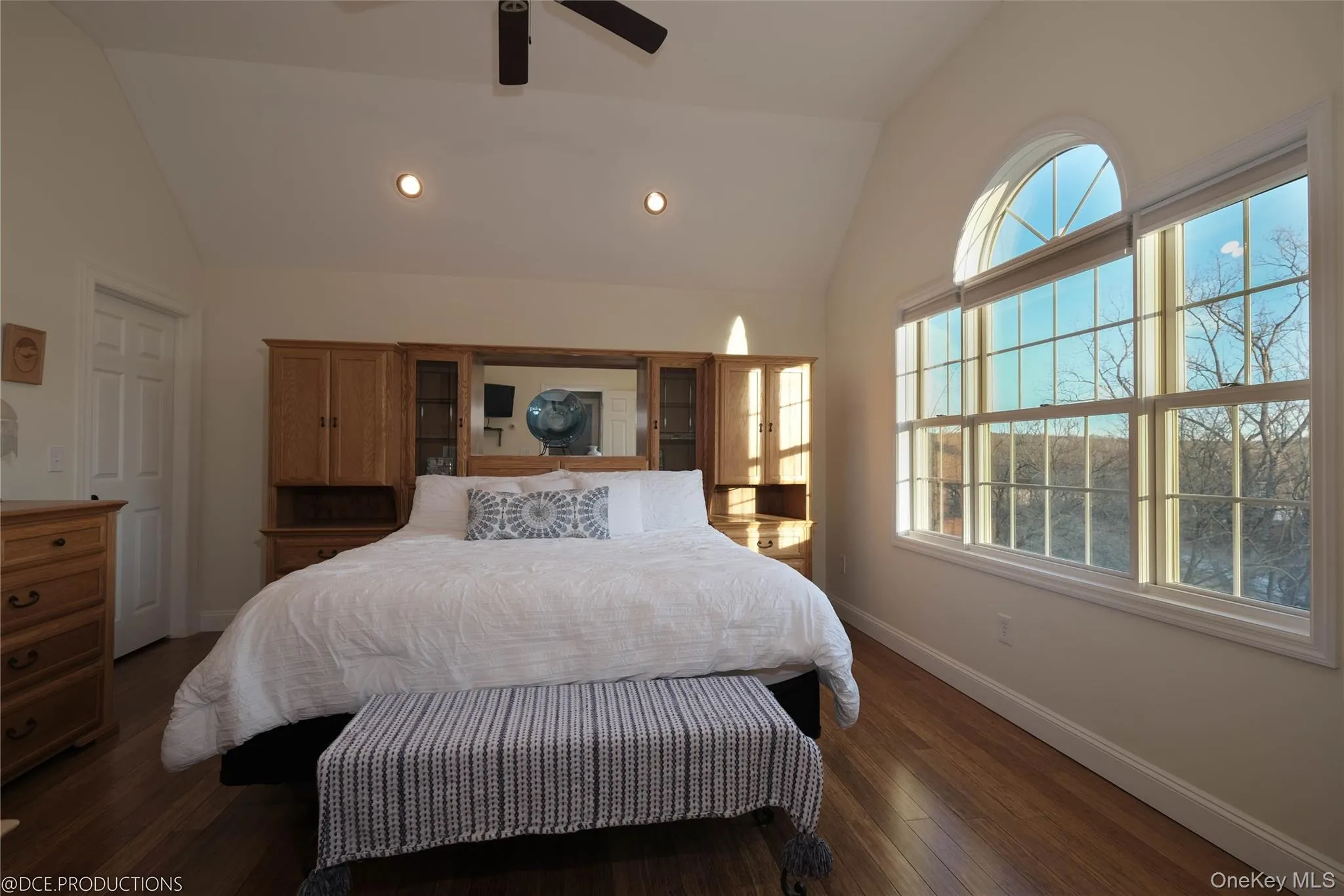 Bedroom featuring hardwood floors, high ceilings, large windows and recessed lighting. Bedroom featuring hardwood floors, high ceilings, large windows and recessed lighting.